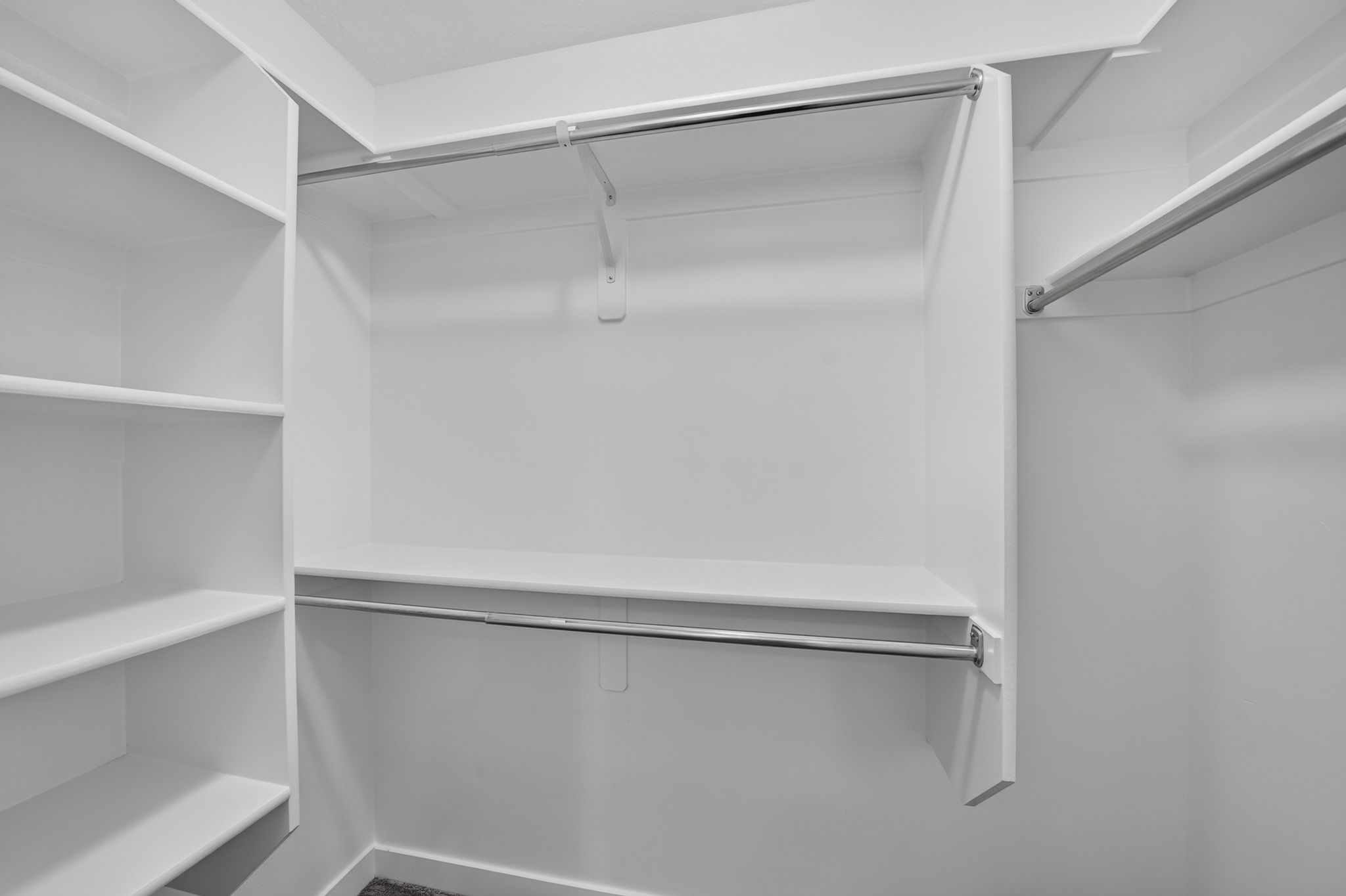 Built-in closet system featuring multiple shelving units and chrome hanging rods