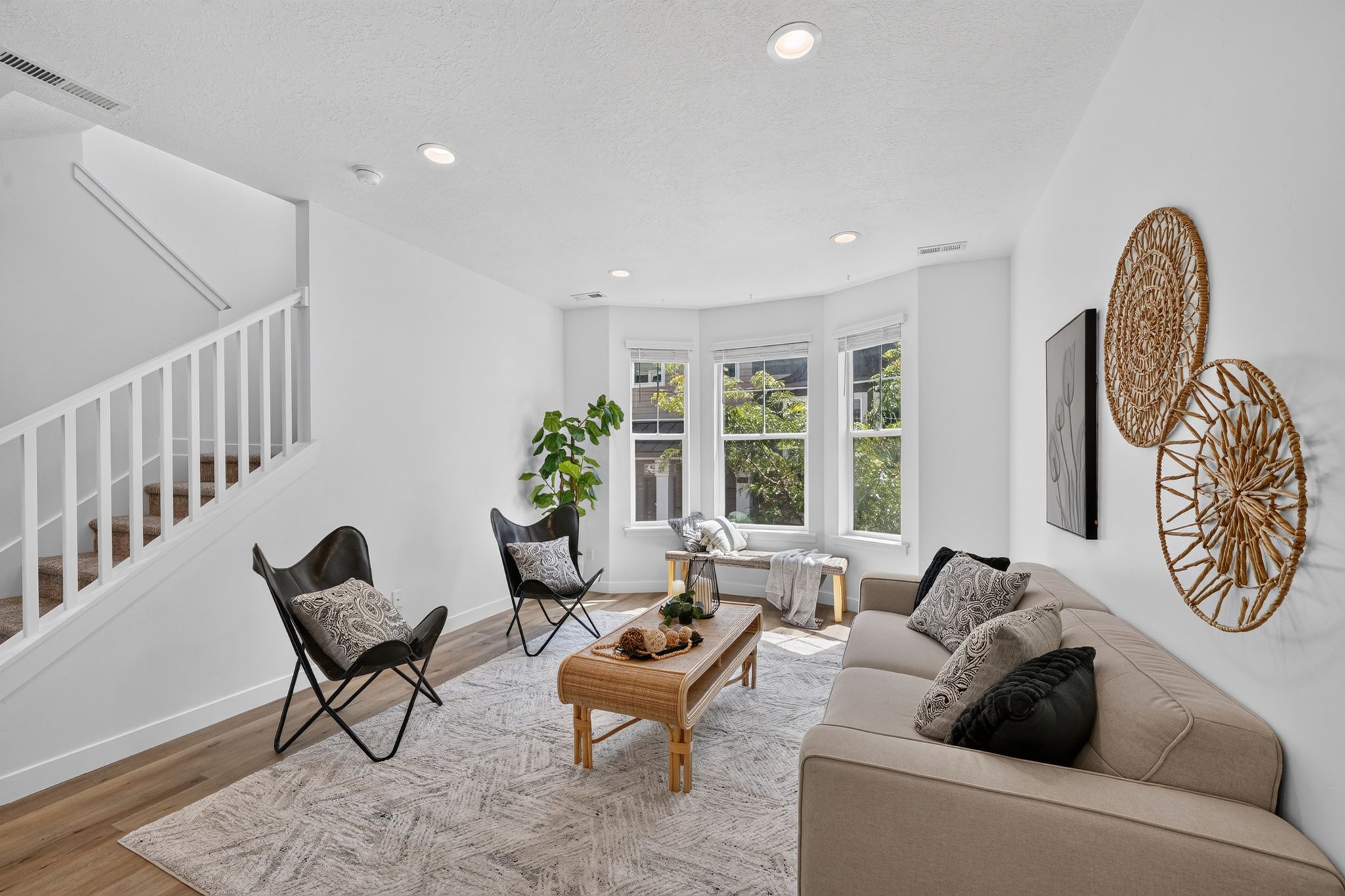 Living area featuring wood-finish flooring, recessed lighting, and a prominent bay window