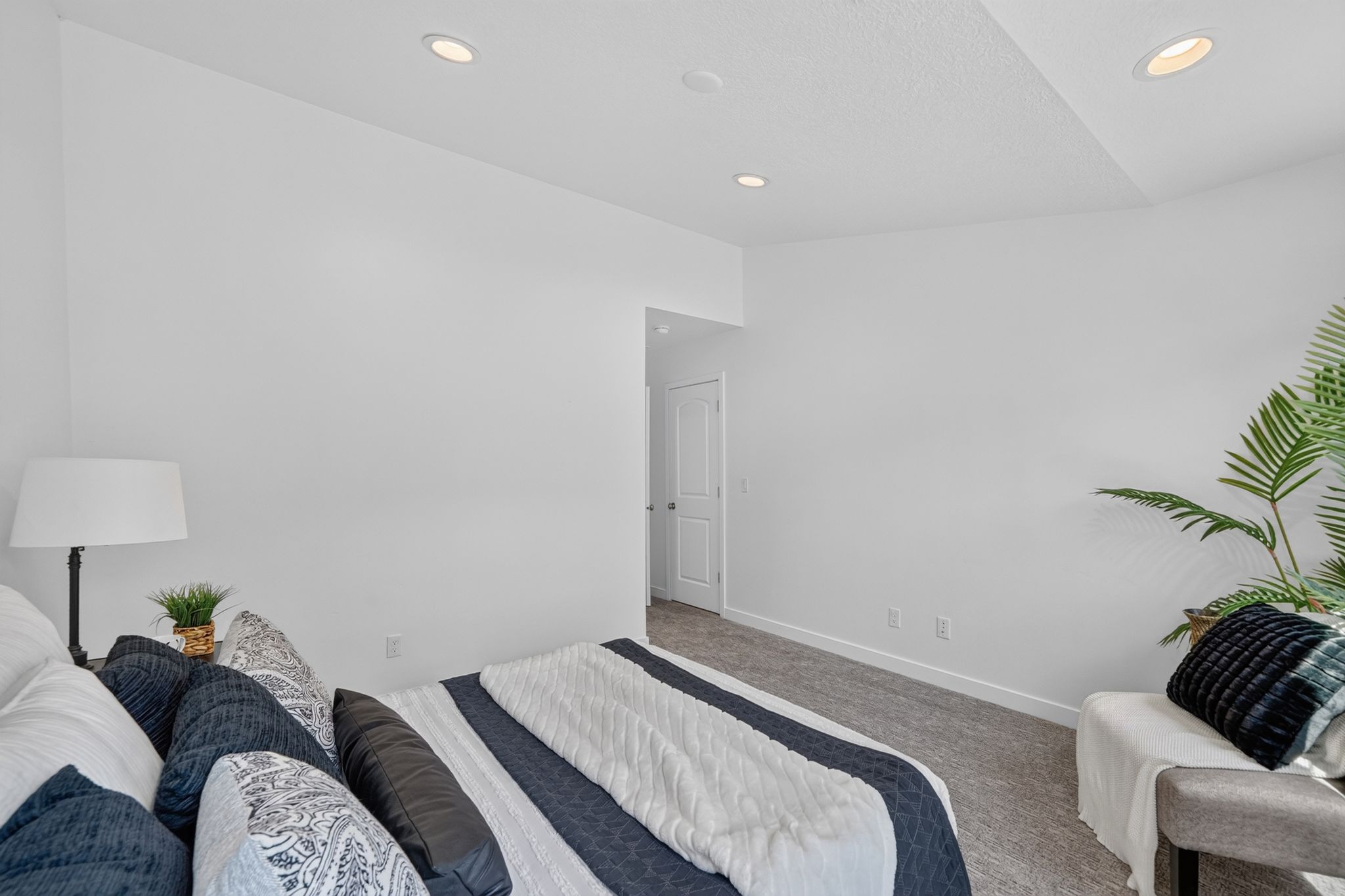 Neutral-toned bedroom with recessed lighting, light-colored walls, and gray carpeting
