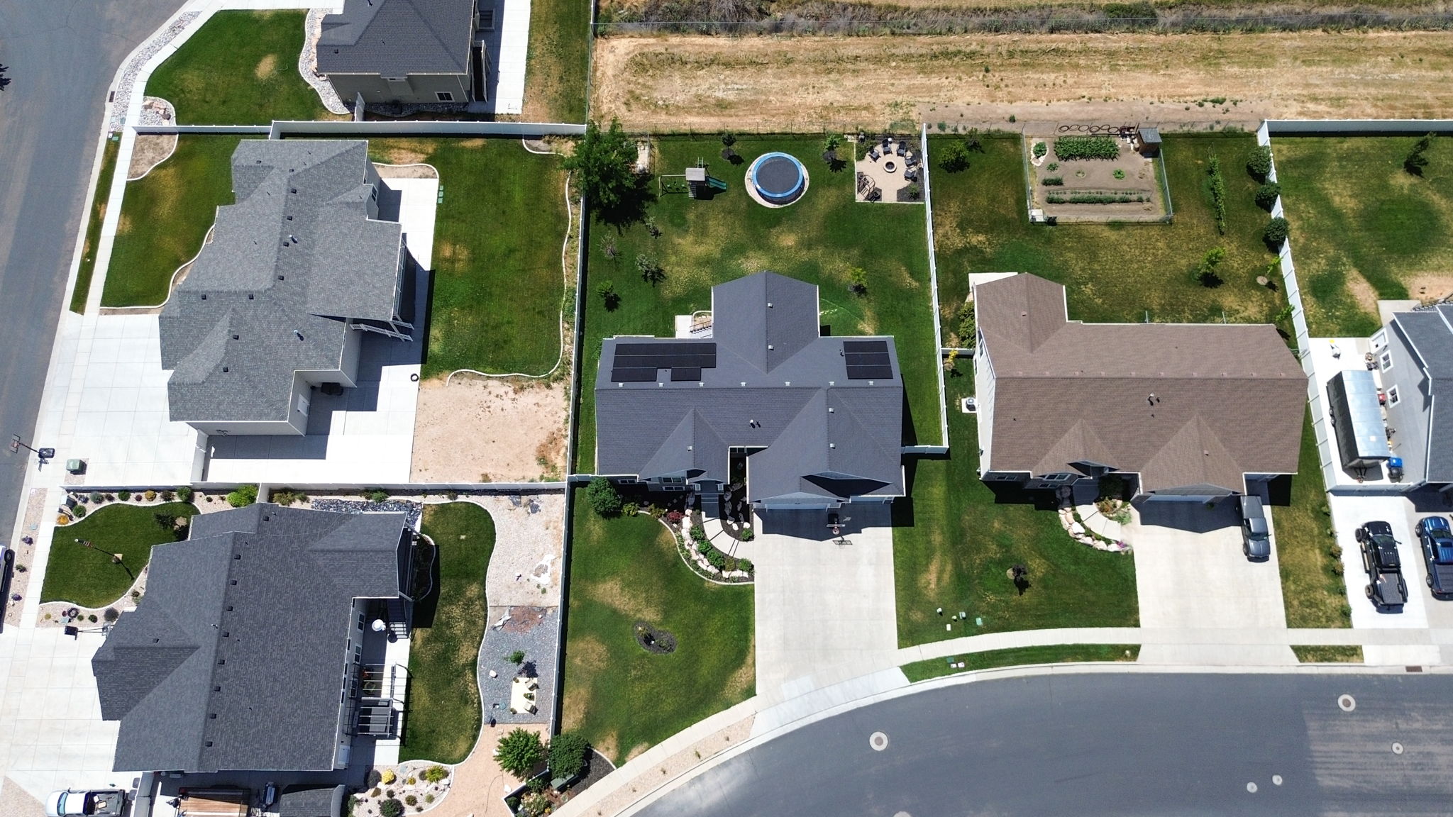 Aerial perspective of a property featuring a dark-toned roof and solar panels