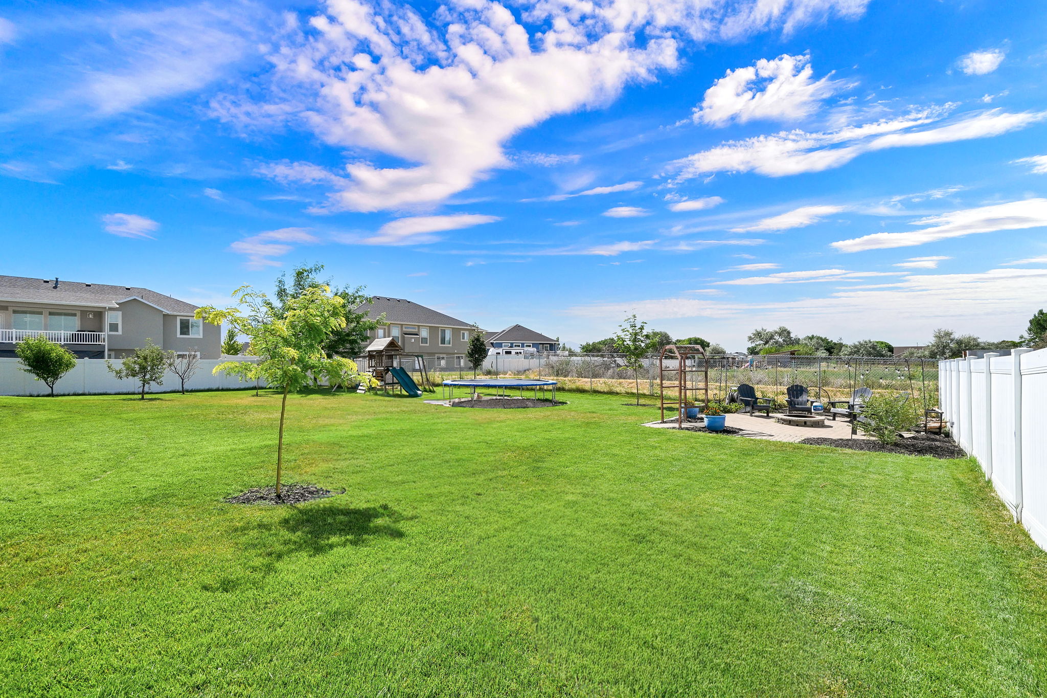 Expansive fenced yard featuring a large grass area, a dedicated patio, and a privacy fence