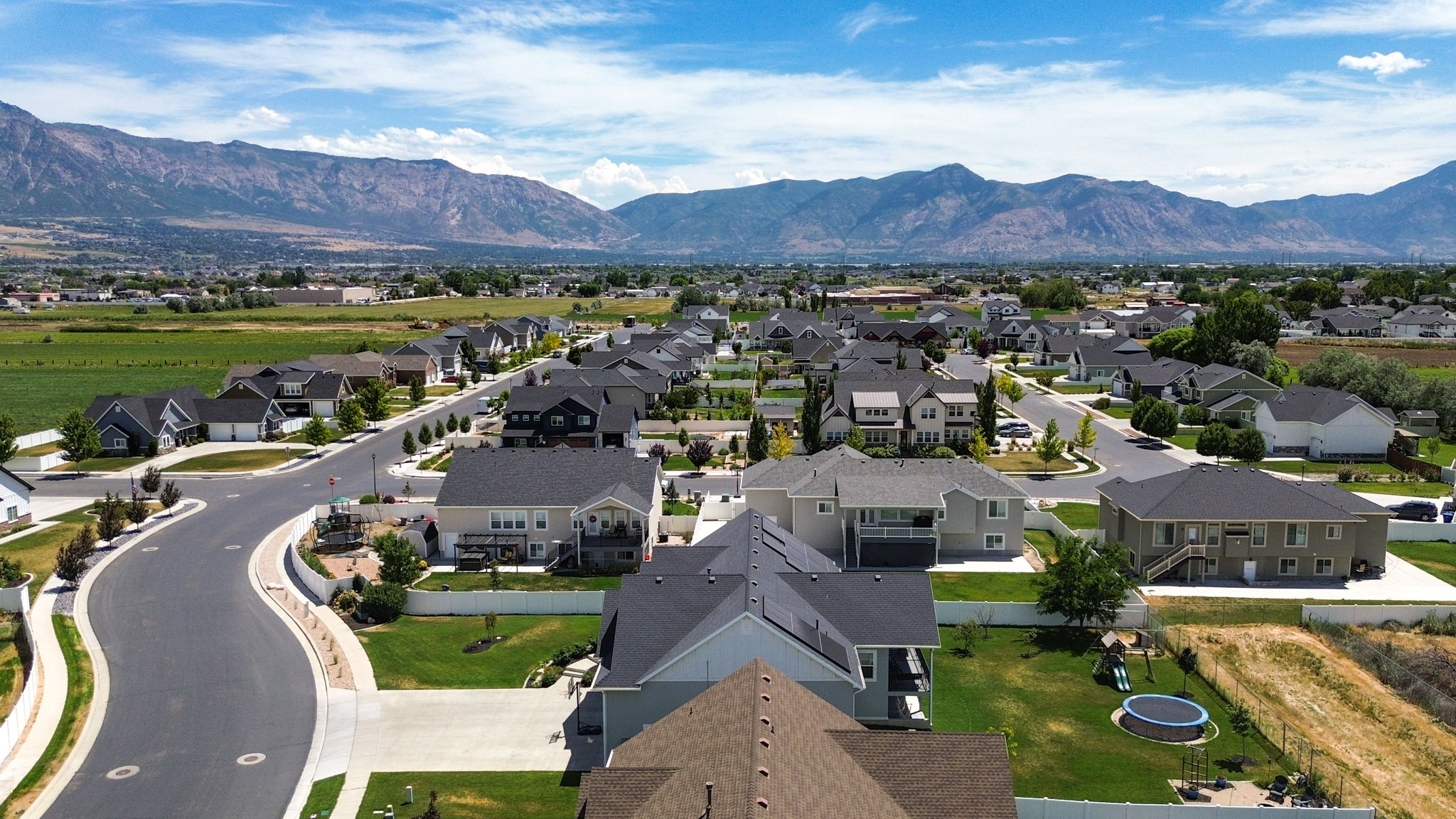 Residential neighborhood with varied architectural styles, asphalt streets, and manicured lawns