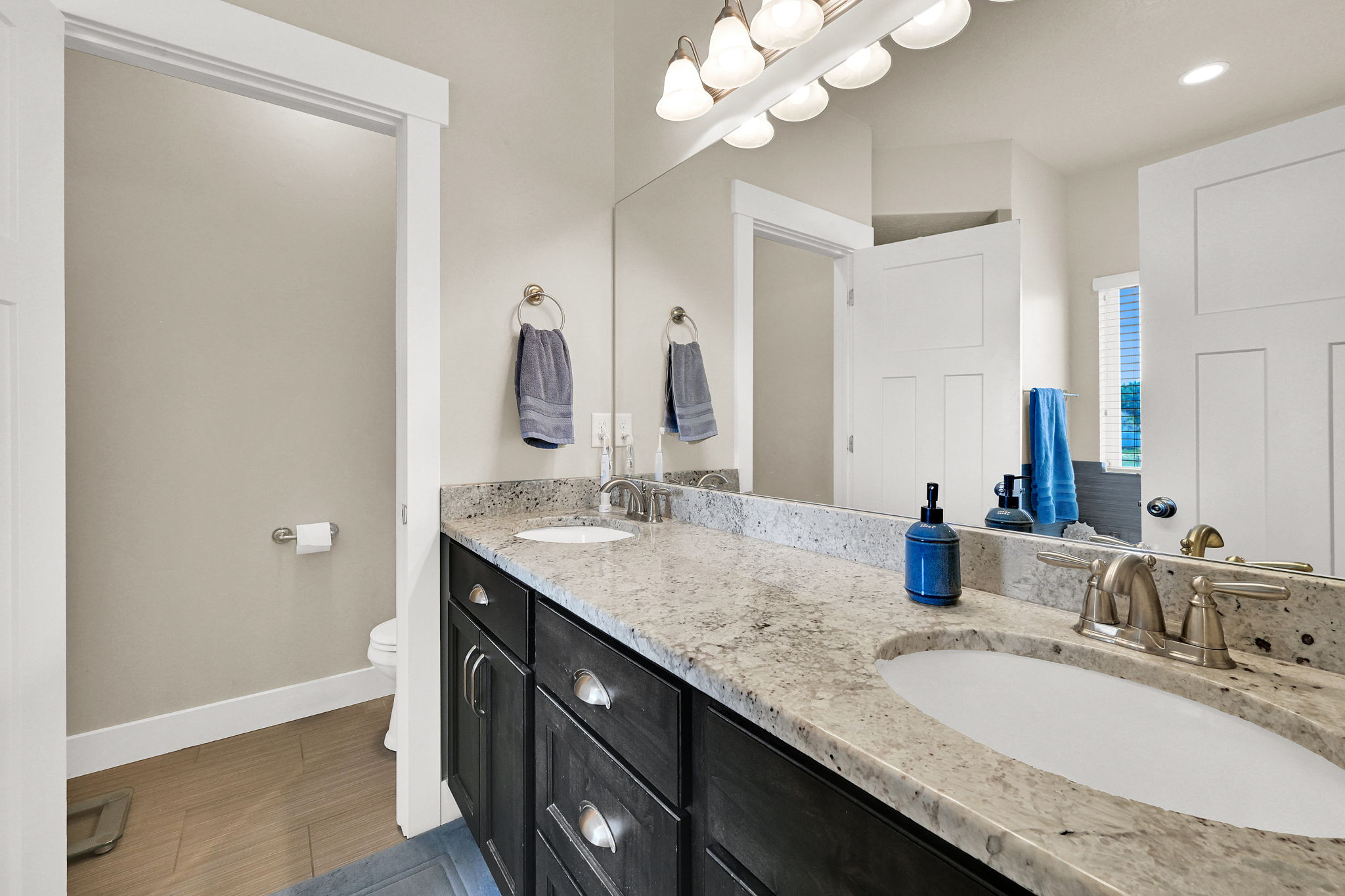 Double vanity featuring granite countertops, undermount sinks, and brushed nickel fixtures