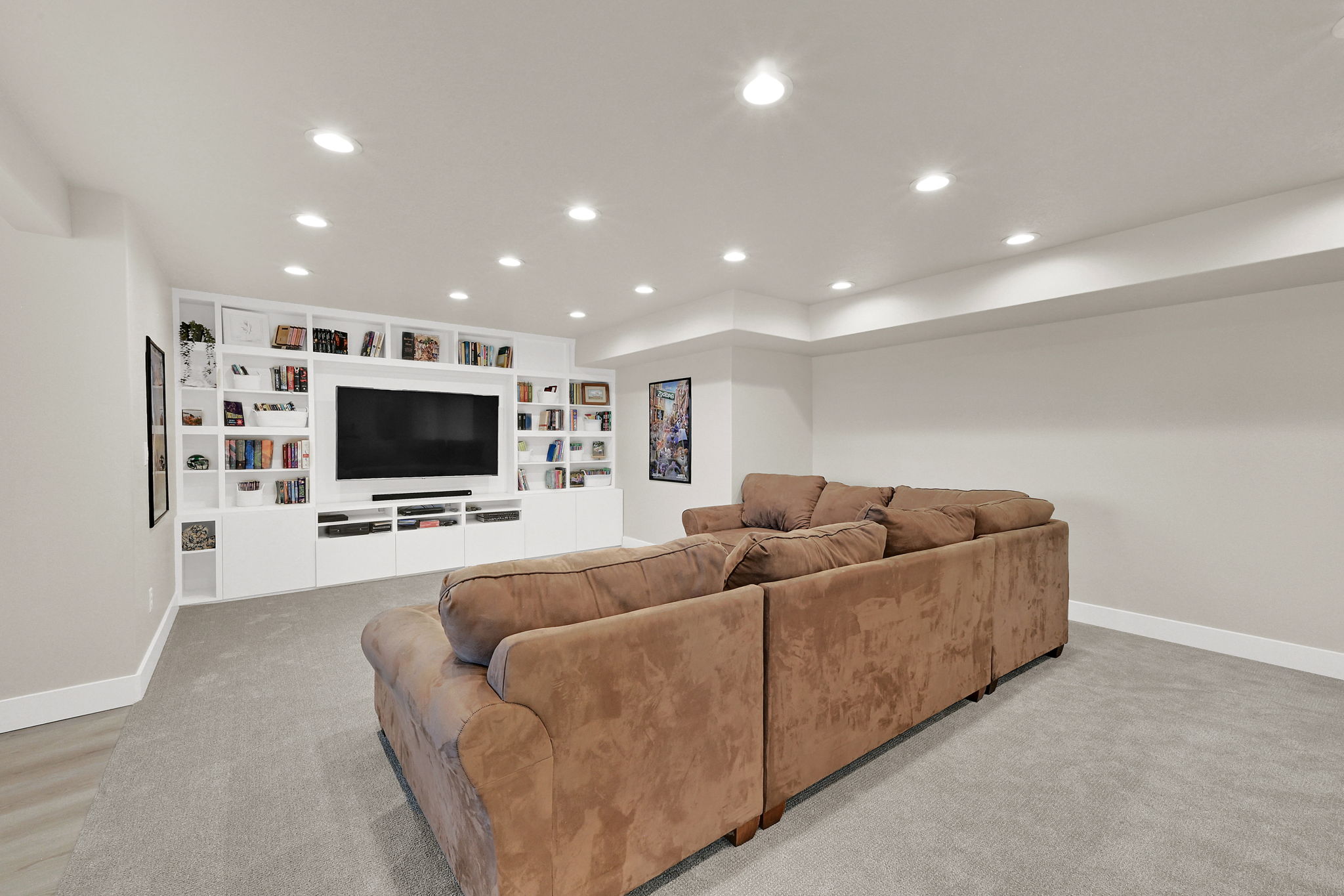 Media room featuring extensive built-in white cabinetry and shelving, recessed lighting, carpet flooring, and white baseboards