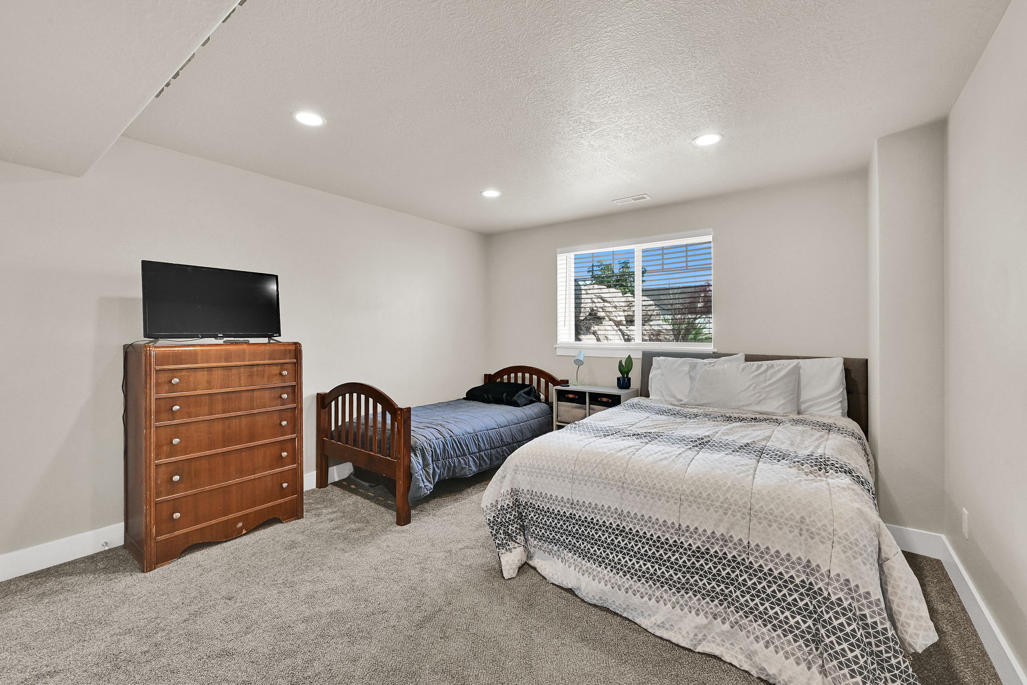 Carpeted room featuring light-colored walls, recessed lighting, and a single window with horizontal blinds