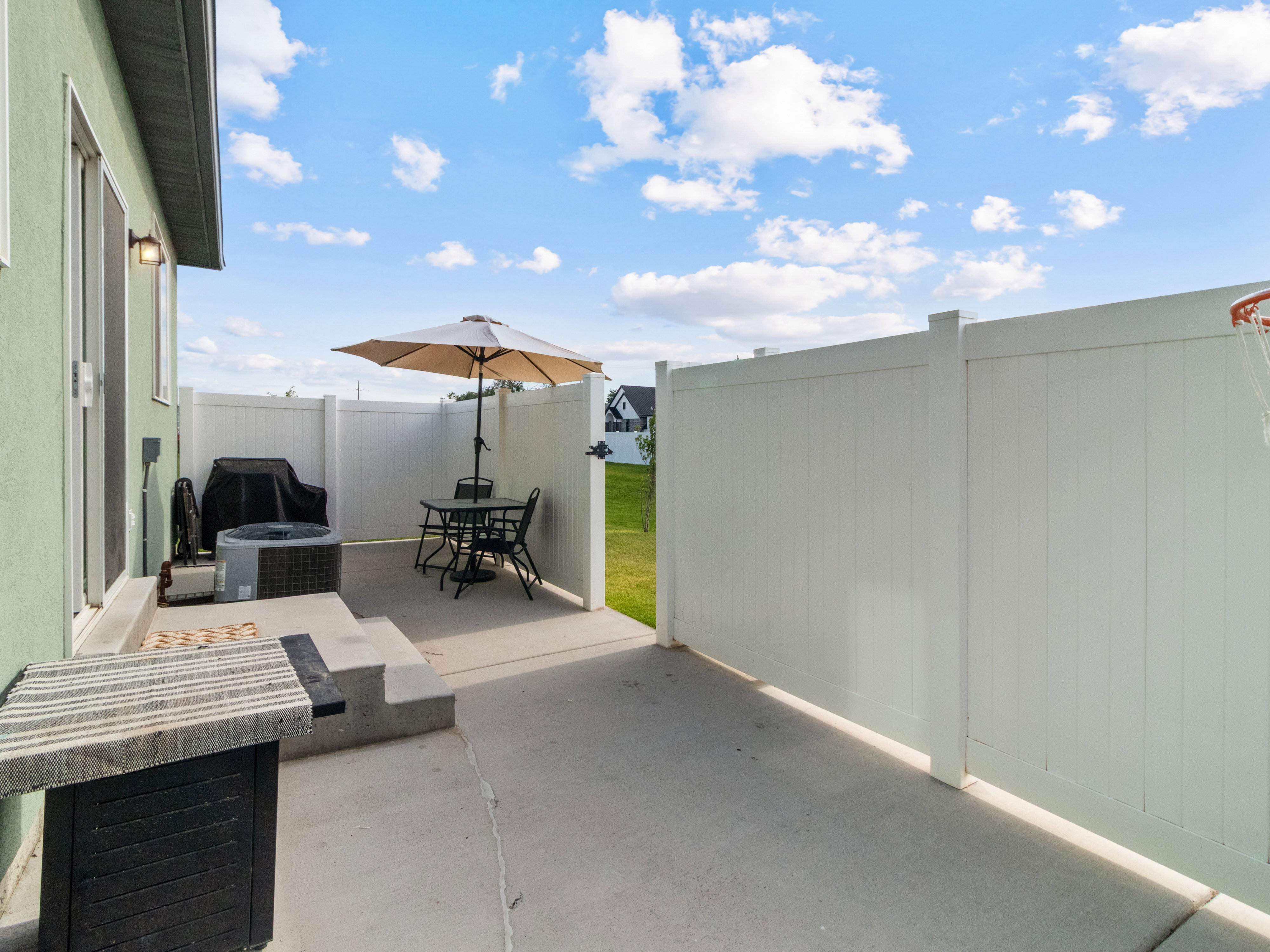 Fenced in patio area featuring a light green stucco exterior.
