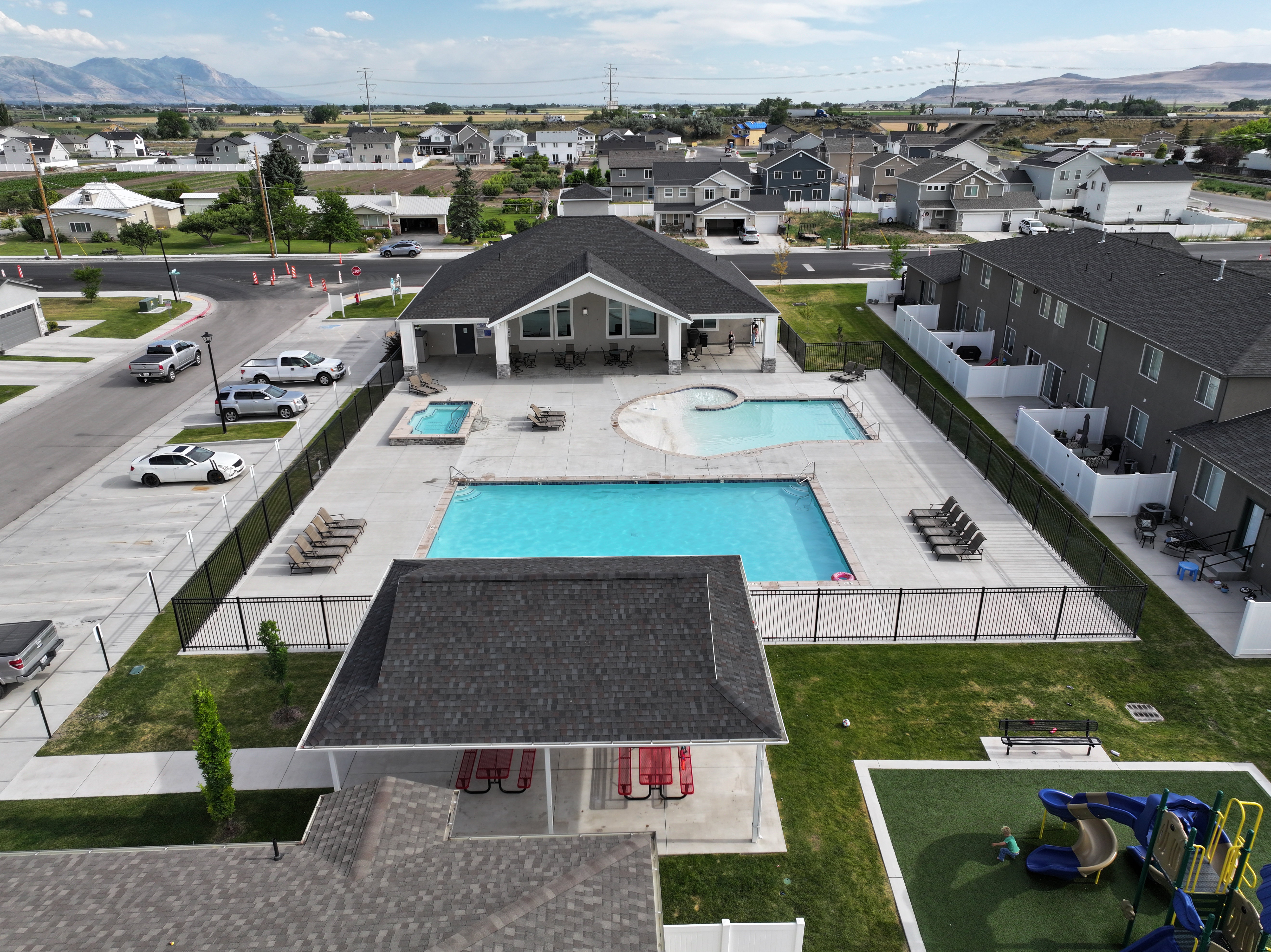 Community amenities featuring a large clubhouse, rectangular swimming pool, an additional freeform pool, and a separate spa