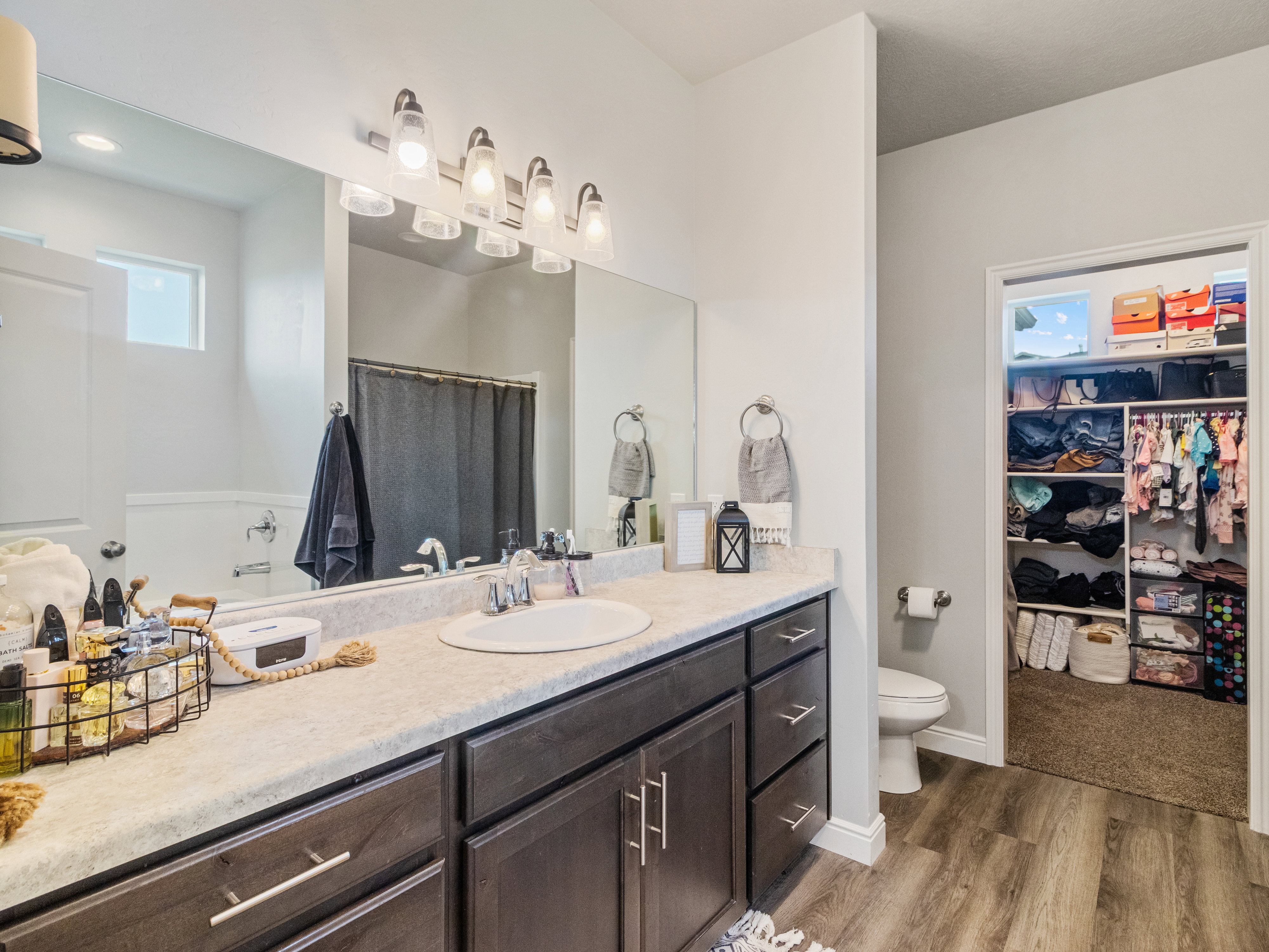 Bathroom vanity featuring a single basin, dark wood-finish cabinetry, and a light-toned countertop