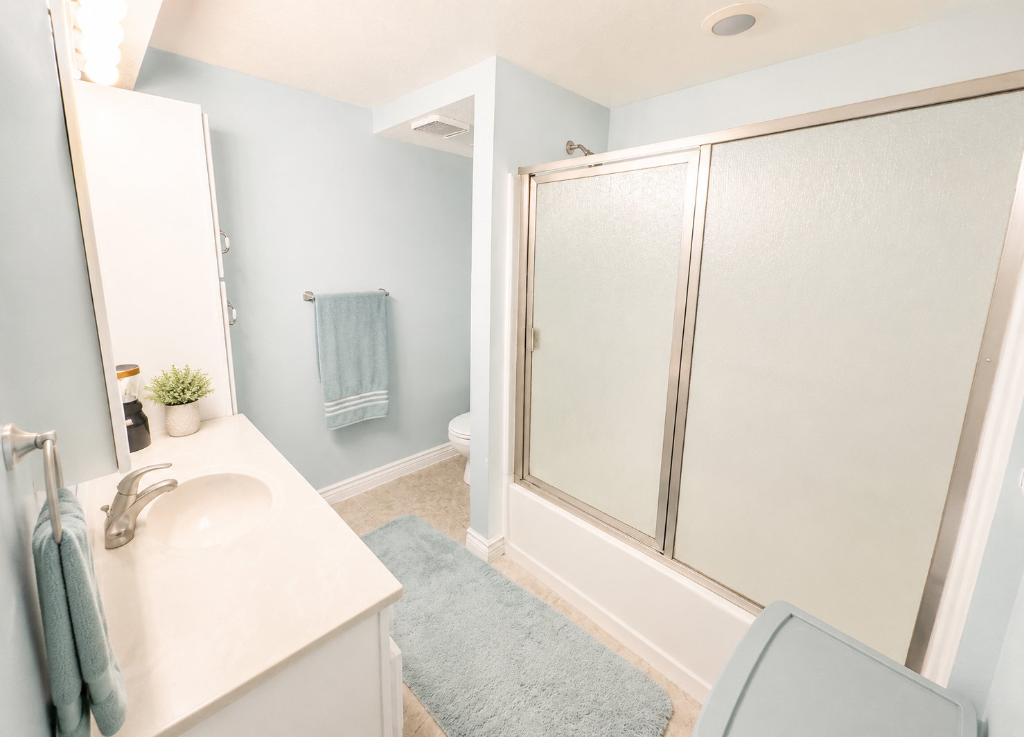 Bathroom featuring a white vanity with a single basin sink, brushed nickel faucet, and a wall-mounted medicine cabinet