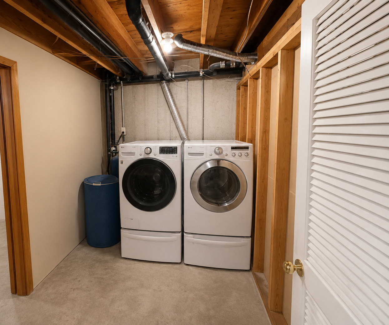 Dedicated laundry area featuring front-loading washer and dryer units with pedestal bases