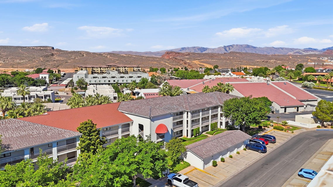 Community featuring multi-story buildings with red tile roofs, balconies, and mature palm trees