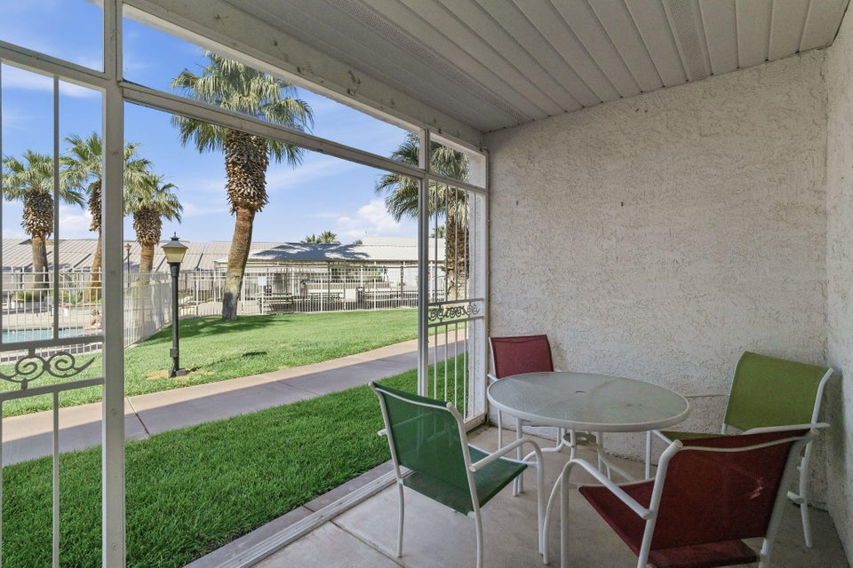 Screened patio with concrete flooring, stucco wall, and slatted ceiling
