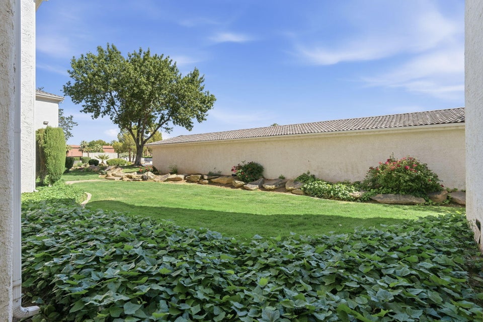 Expansive green lawn with mature trees and perimeter landscaping