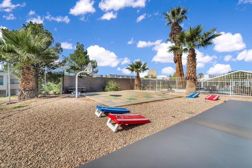 Outdoor recreational space featuring a basketball court with backboard and hoop, surrounded by gravel landscaping