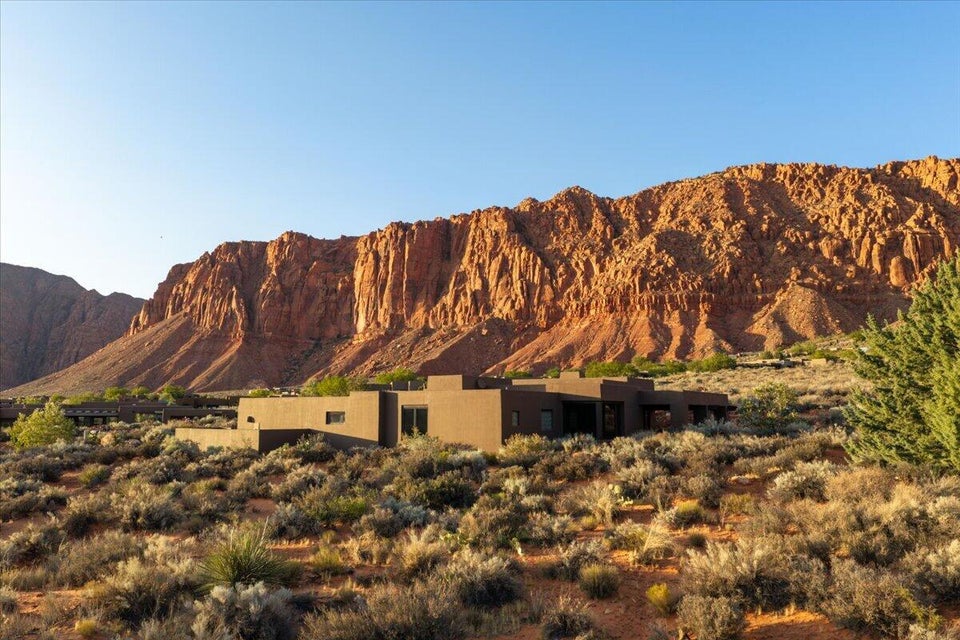 Modern-style architecture with earth-toned exterior, multiple windows, and a flat roofline
