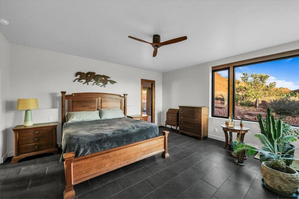 Spacious room featuring dark tile flooring and a ceiling fan