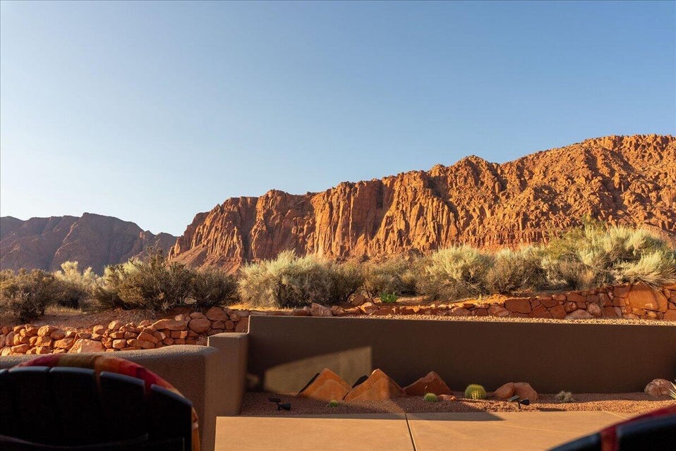 Expansive desert landscape featuring rugged red rock formations and natural shrubbery