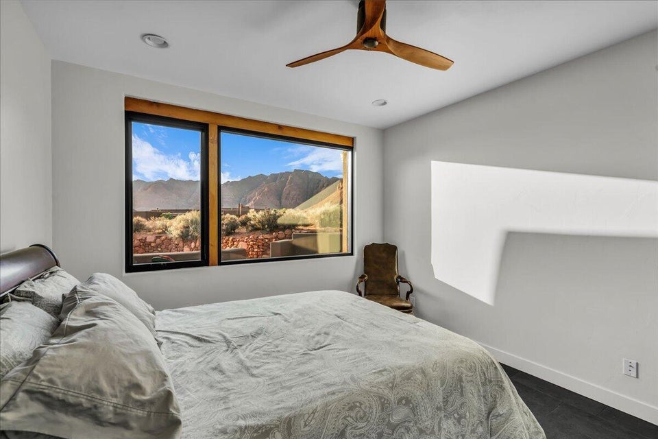 Expansive window with natural wood trim framing mountain and desert scenery