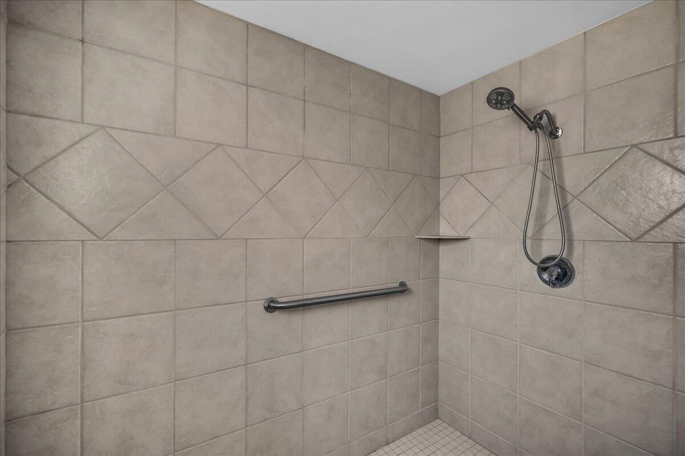 Tiled shower enclosure featuring a decorative accent band