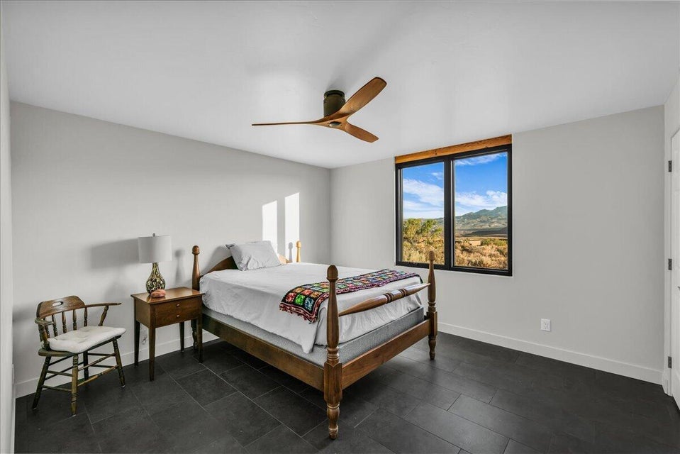 Spacious room featuring dark tile flooring and a ceiling fan