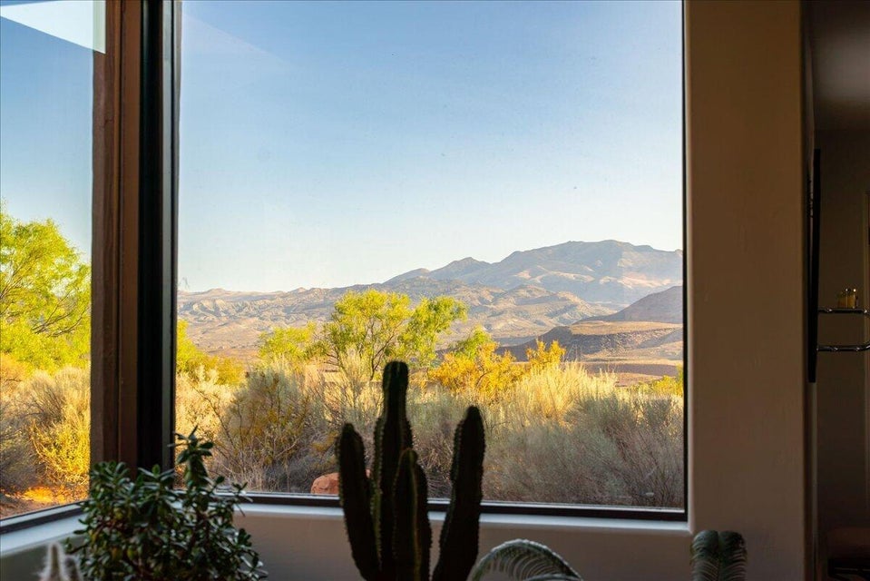Expansive window framing desert vegetation and distant mountains