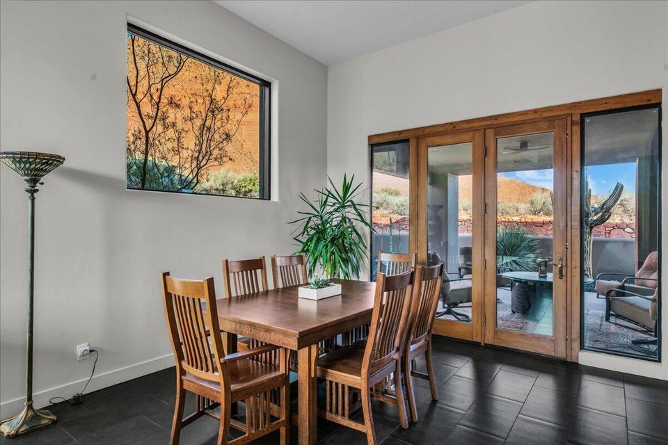 Dining area featuring dark tile flooring, a large horizontal window, and wood-framed glass patio doors