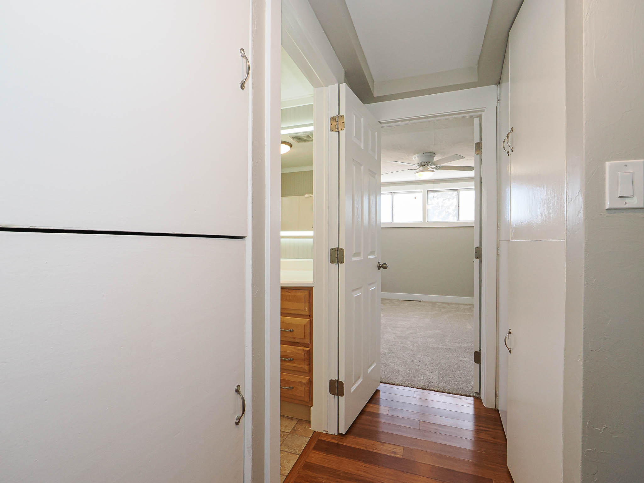 Hallway featuring wood-finish flooring, built-in cabinetry, and neutral wall tones