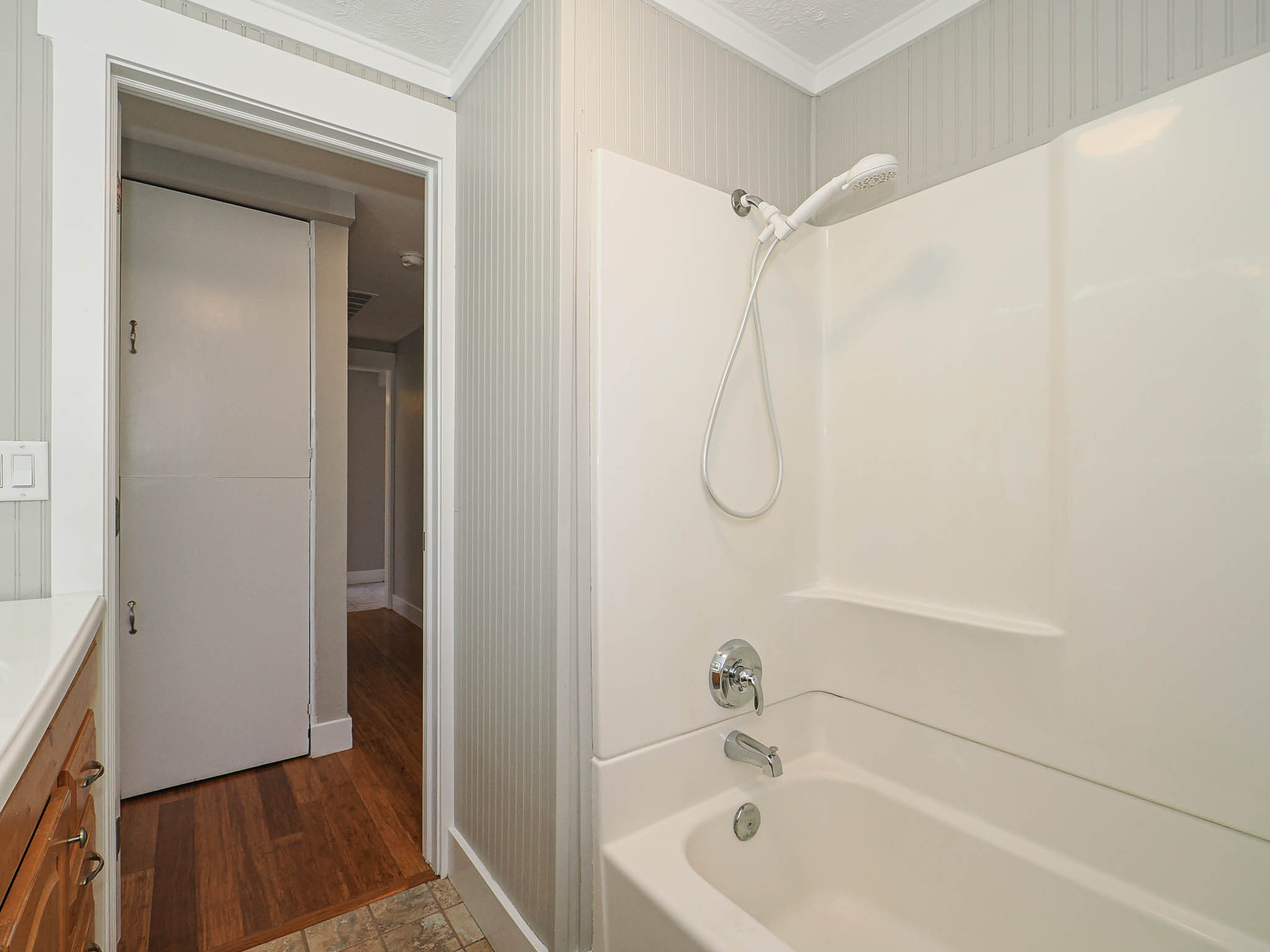 White integrated tub and shower unit with chrome fixtures