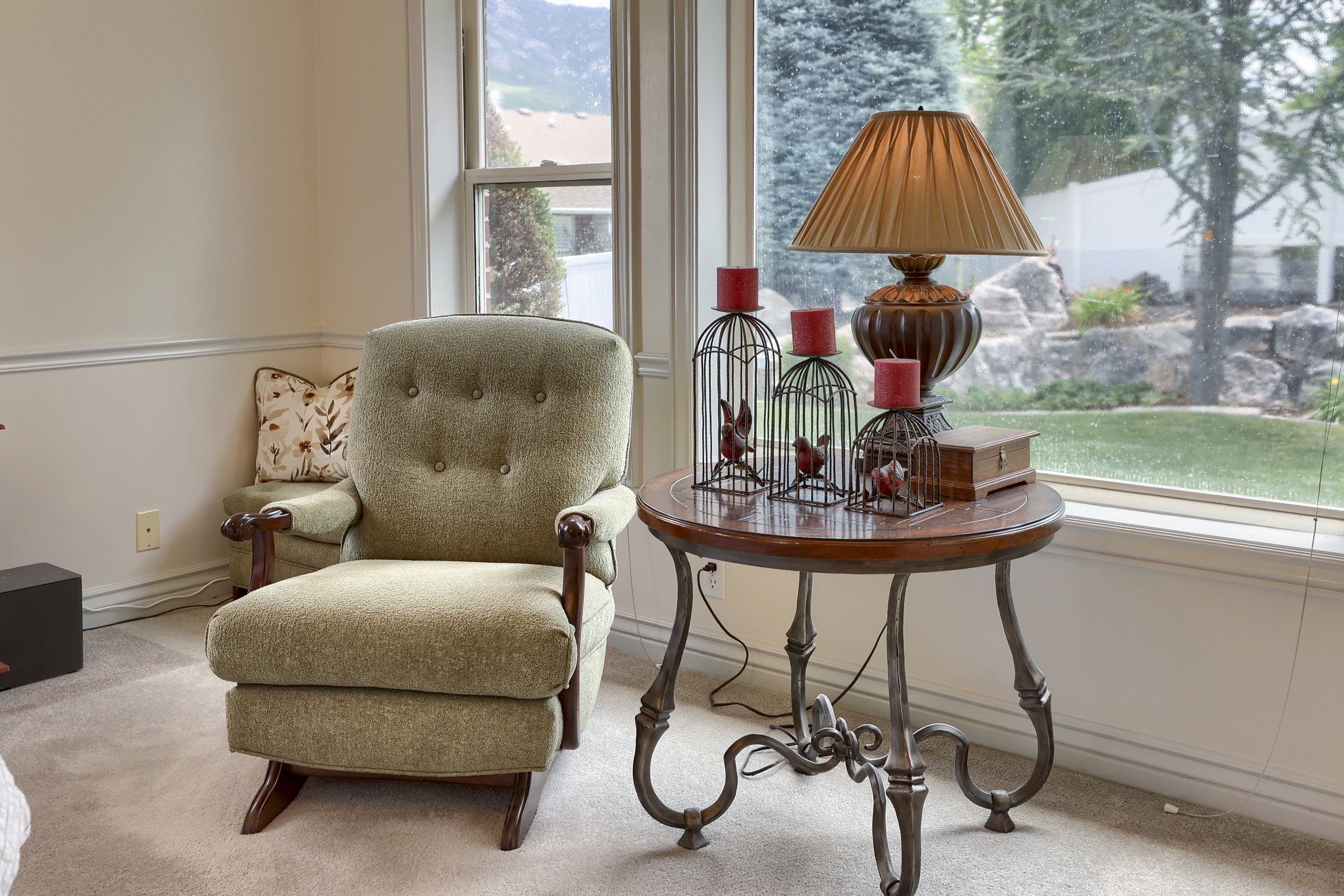 Bright interior space featuring large windows, neutral-toned walls with chair rail molding, and soft carpeting