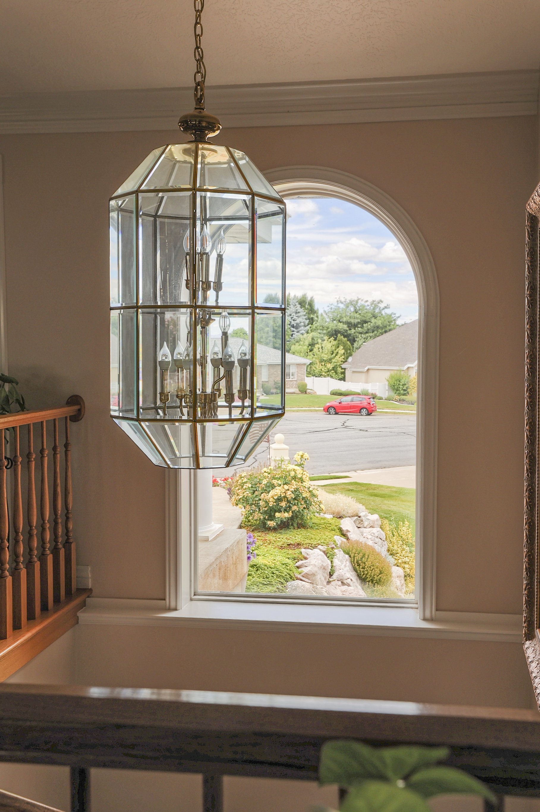 Ornate brass and glass chandelier illuminating an arched window