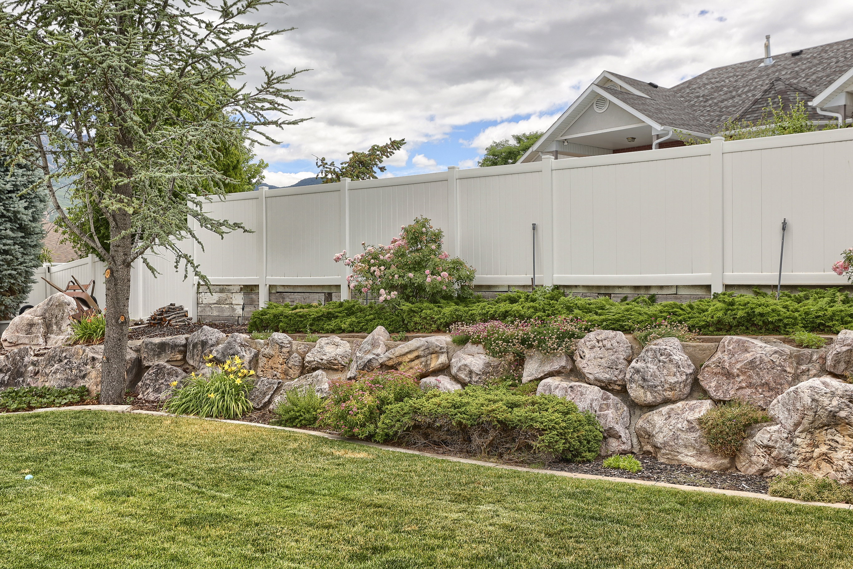 Expansive green lawn bordering a natural rock retaining wall