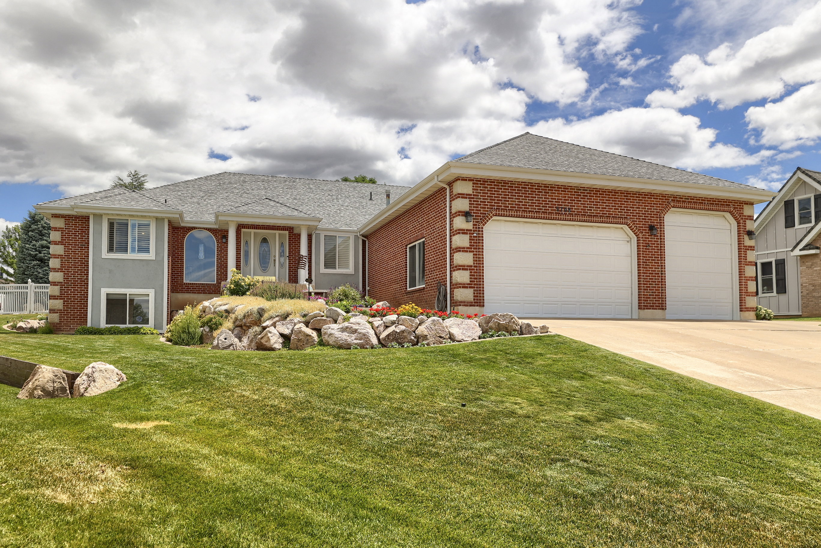Brick and stucco exterior with a prominent three-car garage