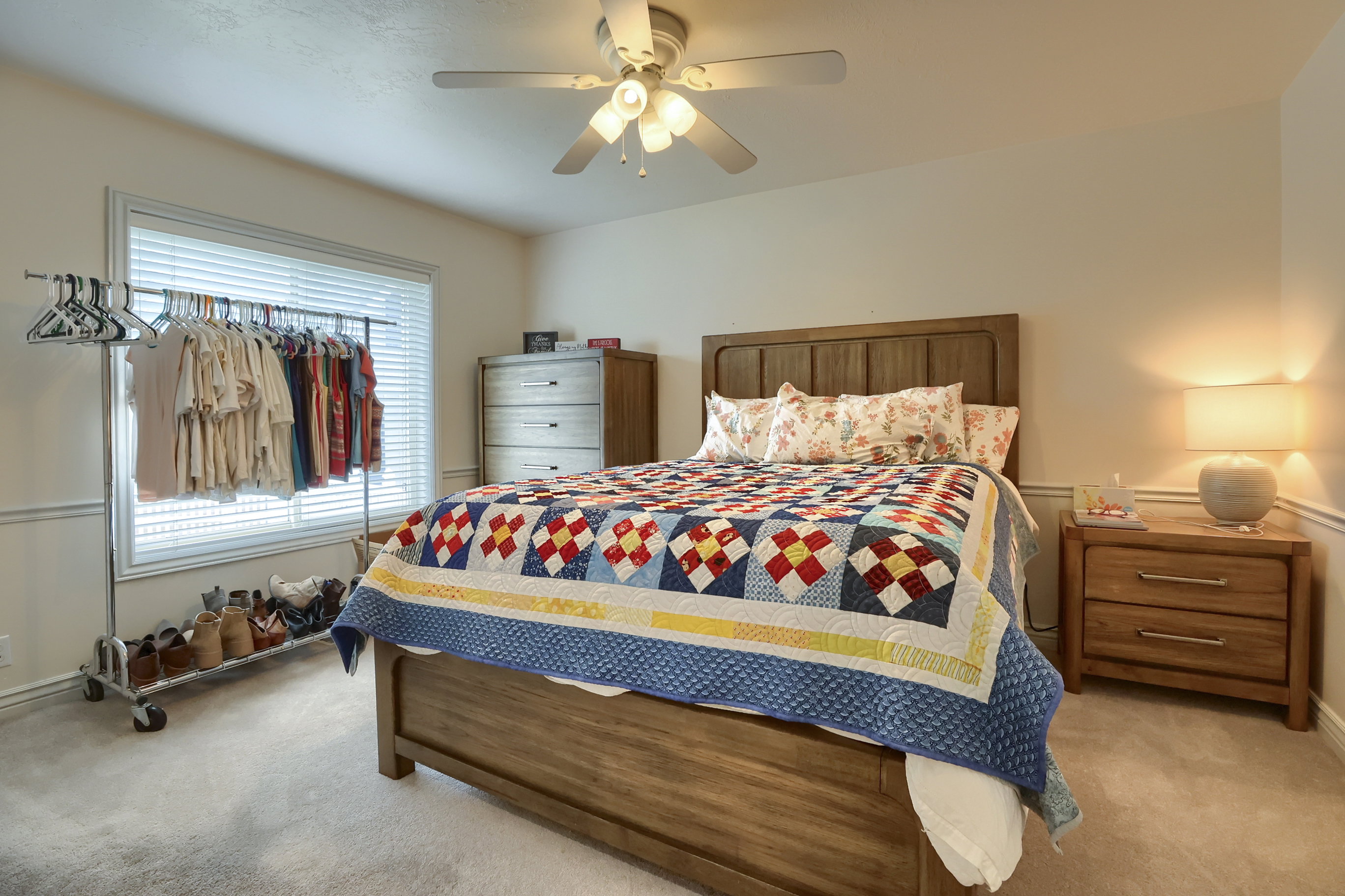 Carpeted bedroom featuring a ceiling fan, a window with blinds, and white wall trim