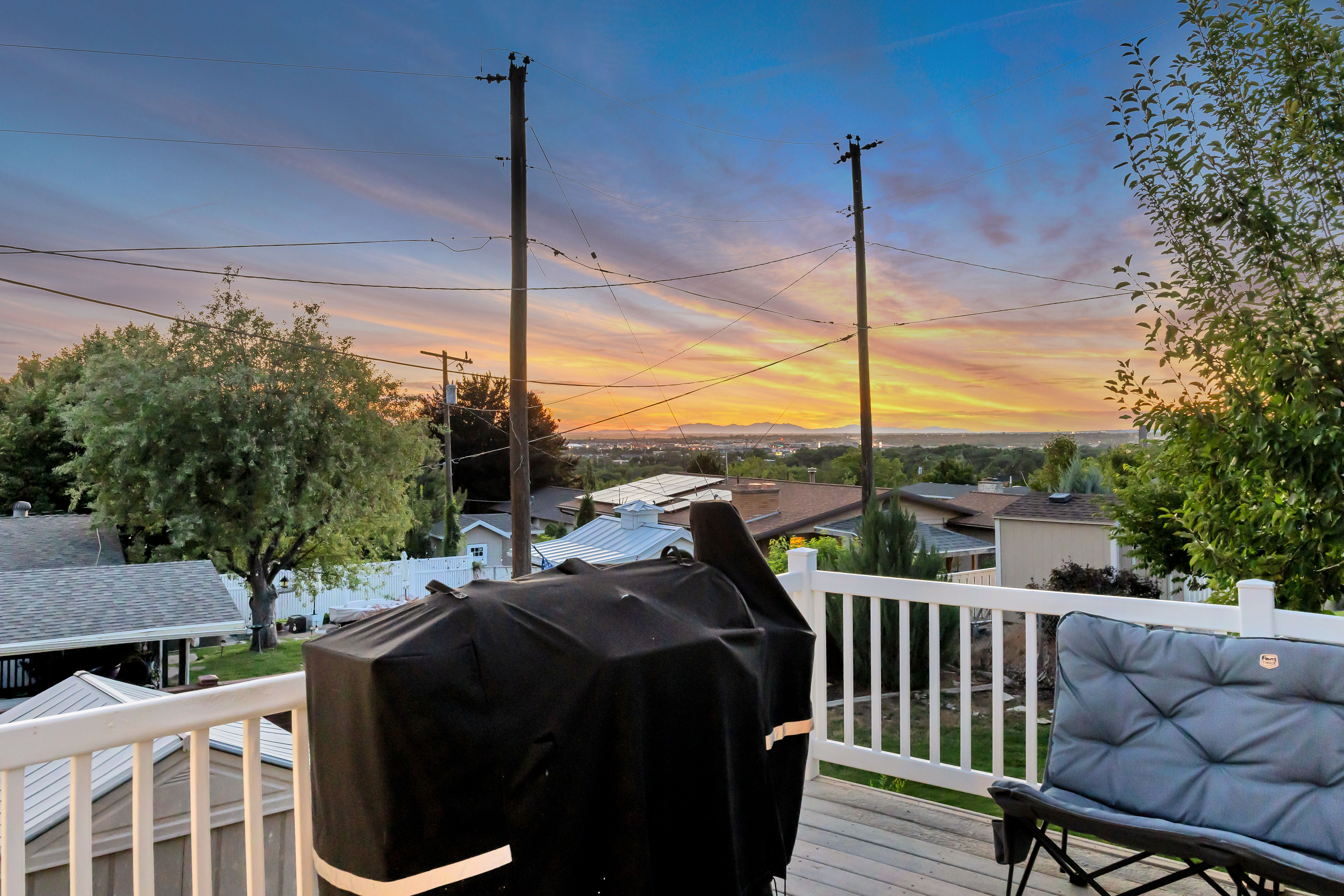 Expansive outdoor deck featuring wood-finish flooring and white picket railing
