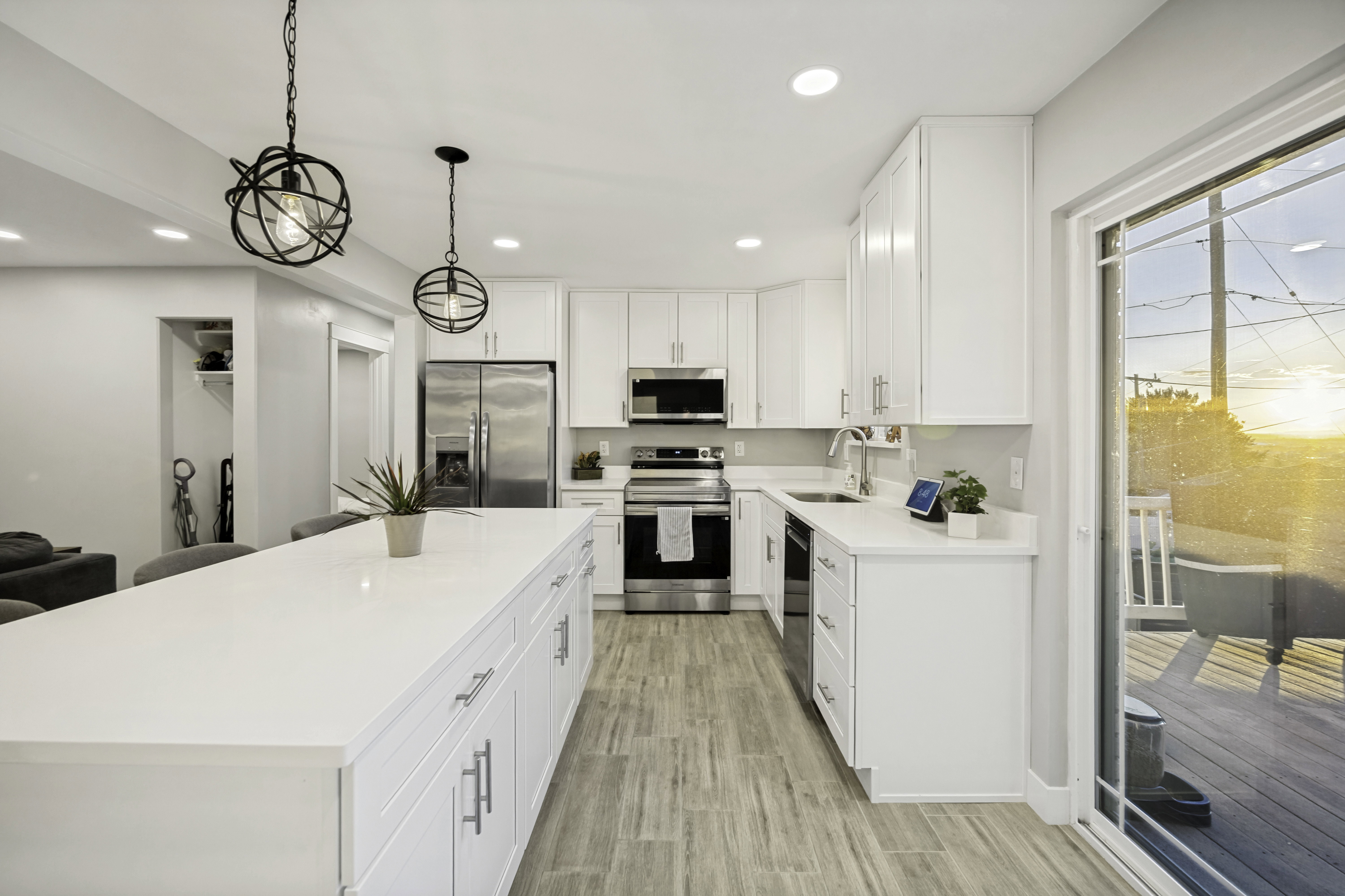 Kitchen featuring a large island with white countertops, white cabinetry, and stainless steel appliances.