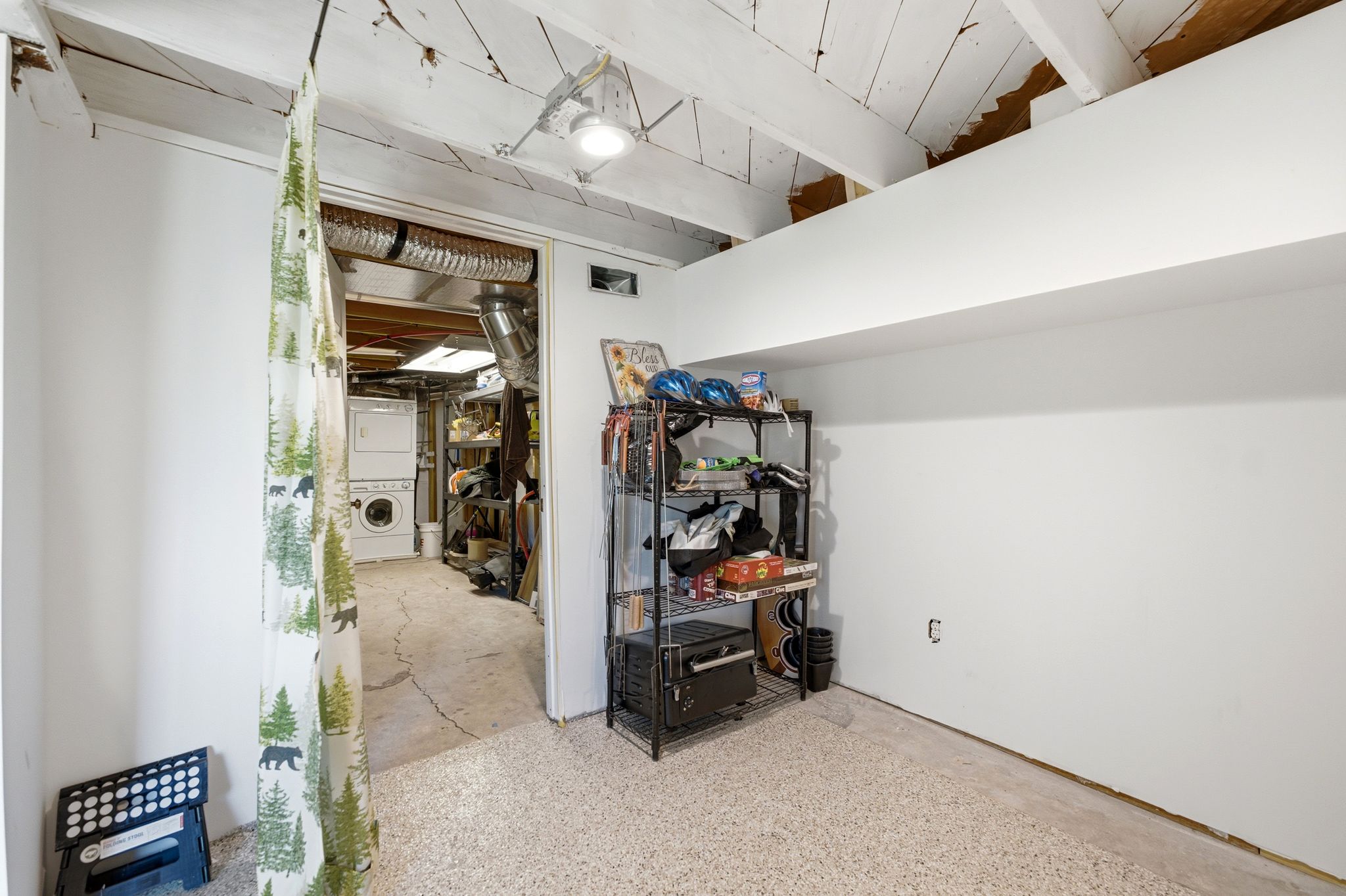 Lower-level space featuring a light-colored, textured floor