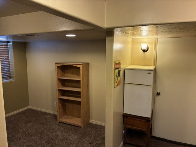 Carpeted room featuring a window with horizontal blinds and recessed lighting