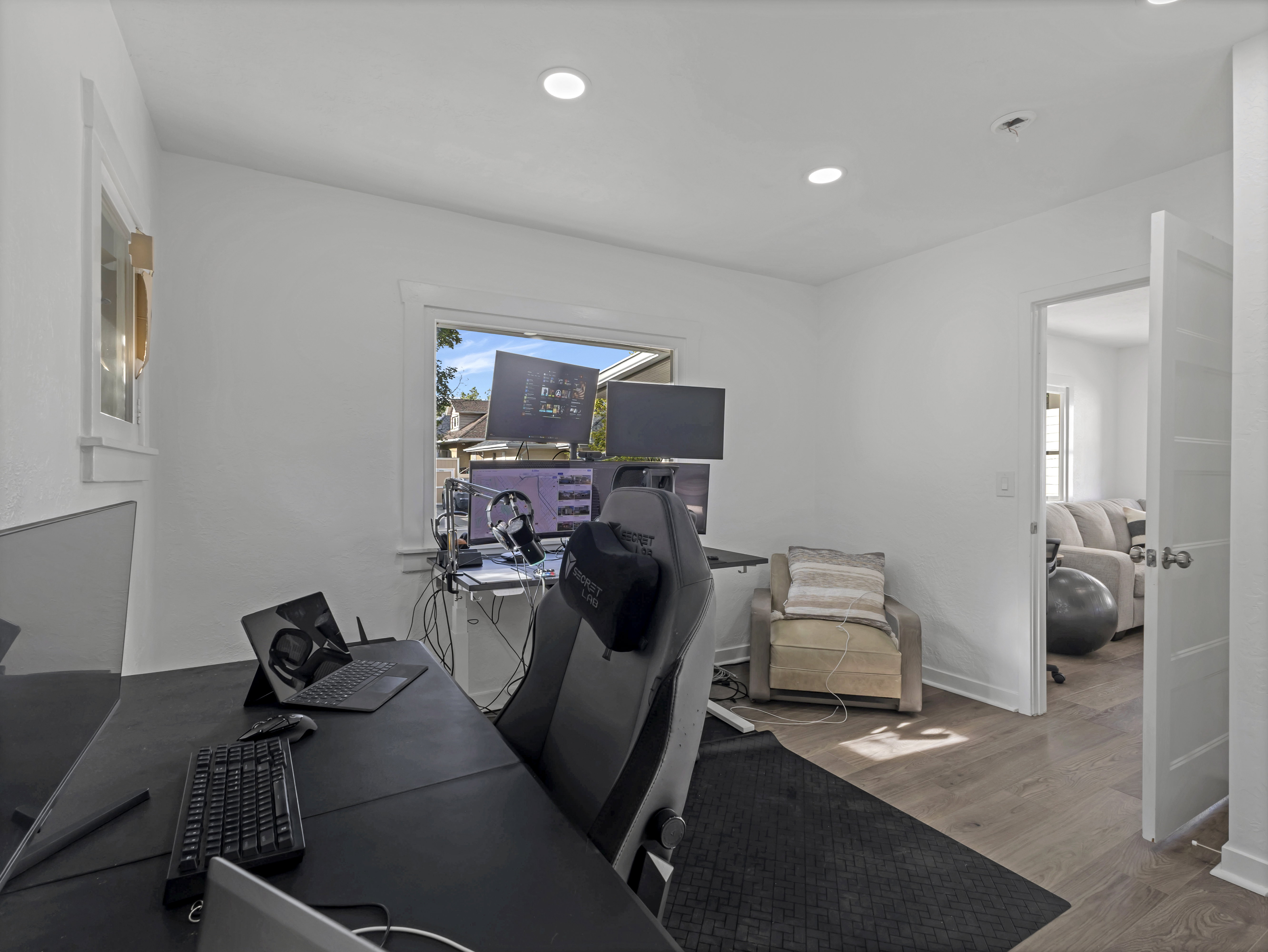 Bright room featuring recessed lighting, a window with exterior views, light wood-finish flooring, and white trim