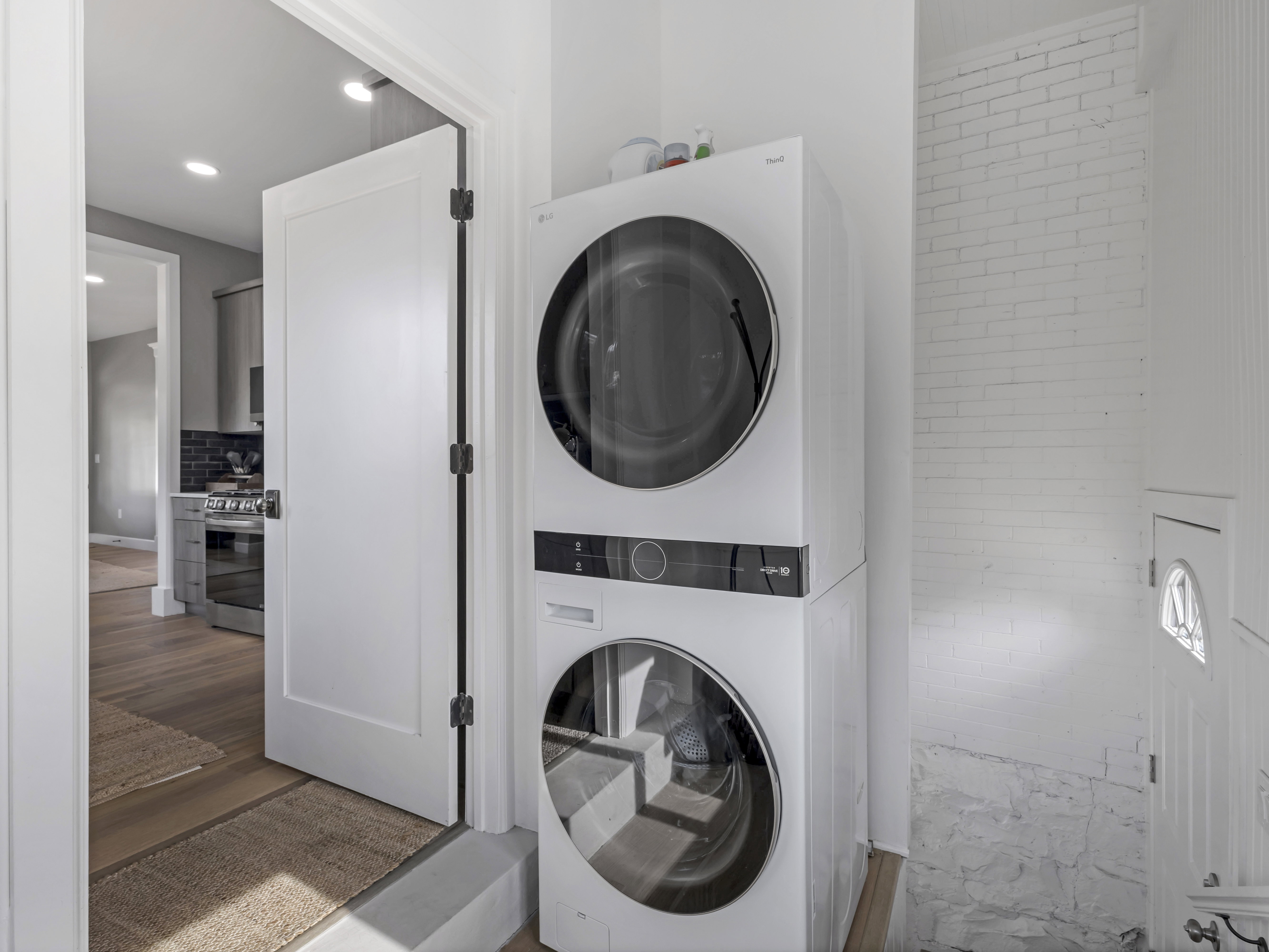 Stacked laundry appliances featuring clear appliance doors and dark control panels