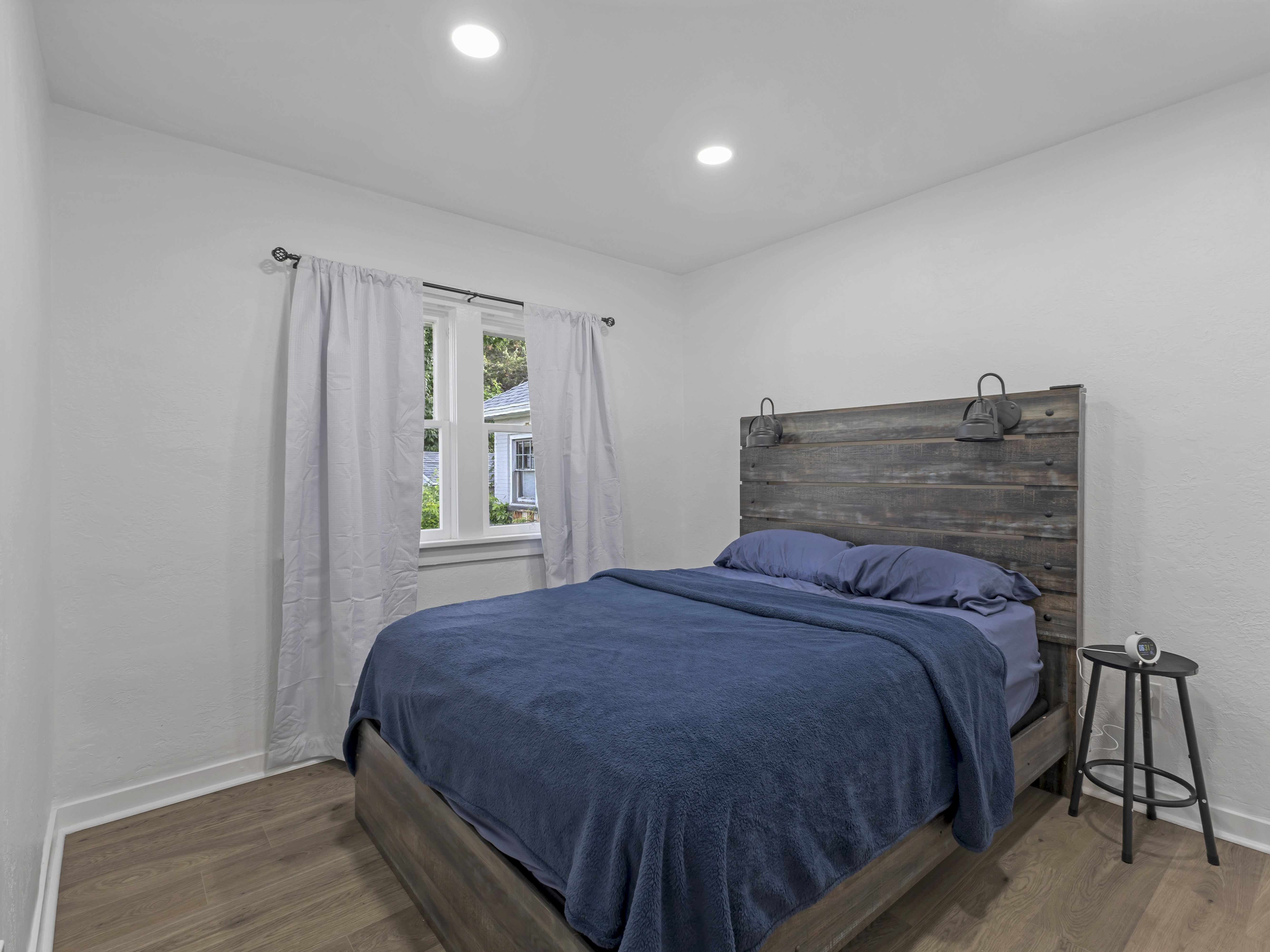 Bedroom featuring recessed ceiling lighting, wood-finish flooring, and white baseboards