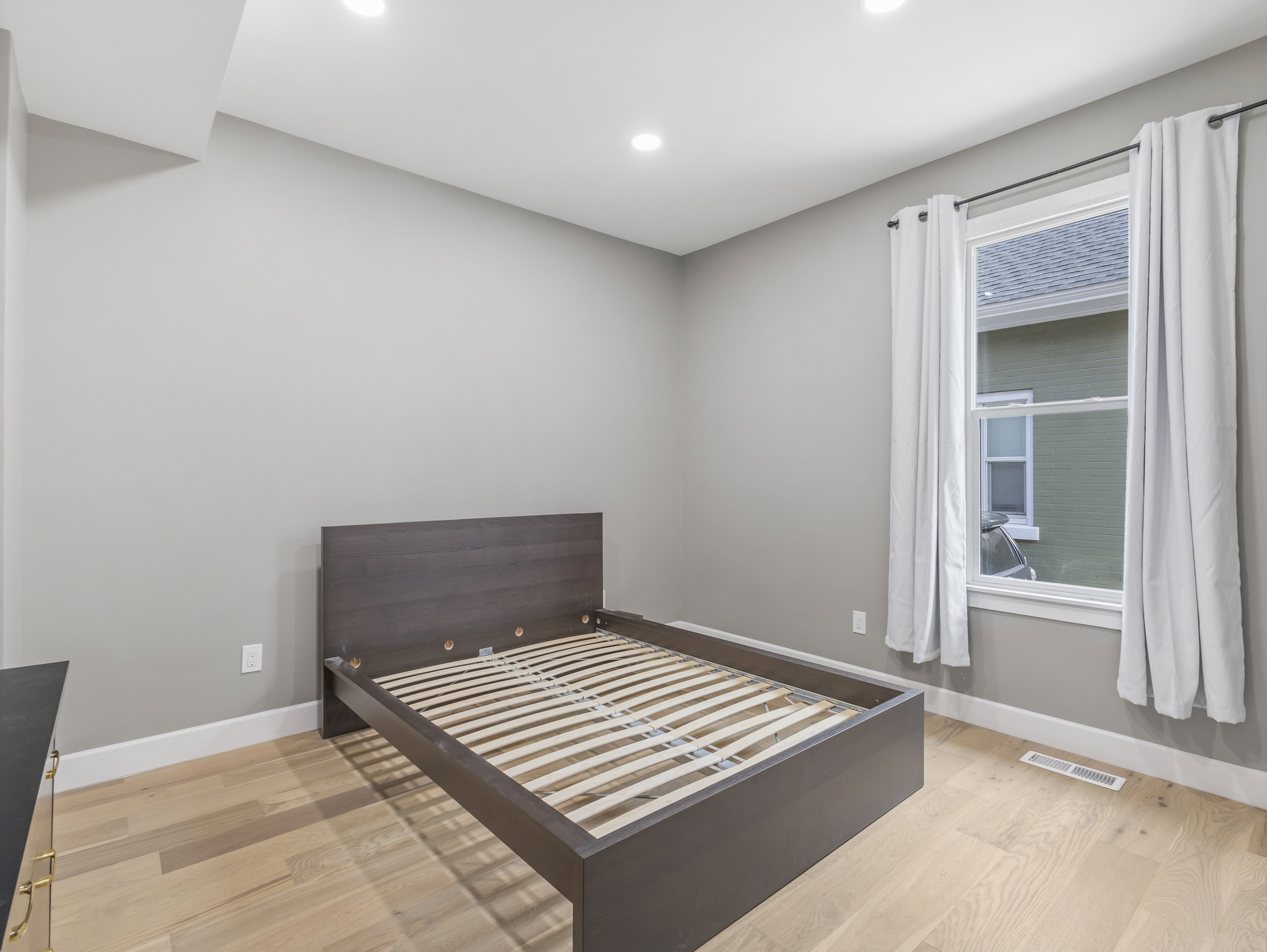 Room with light wood-finish flooring and recessed lighting