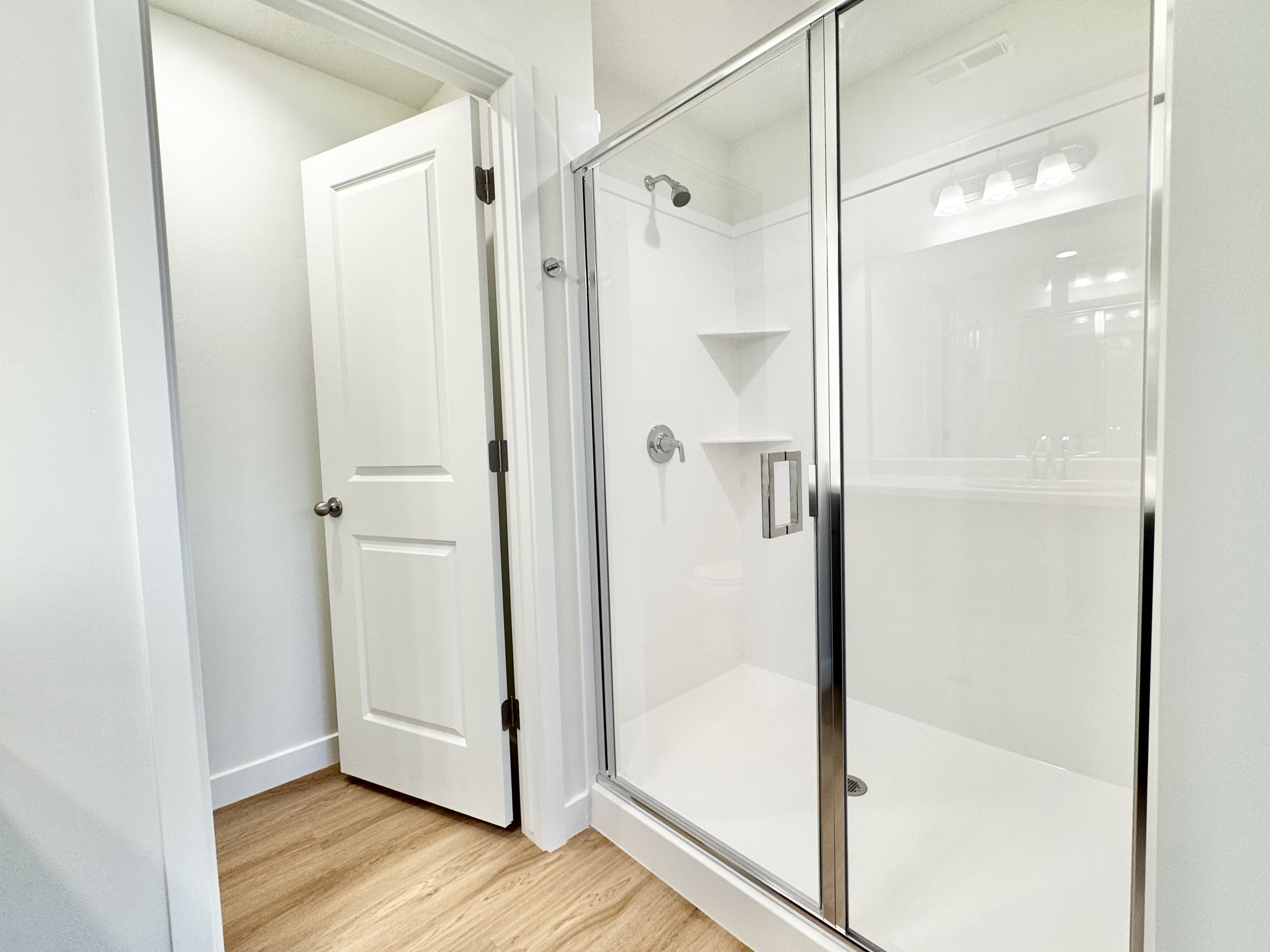 Spacious shower enclosure featuring clear glass and chrome hardware