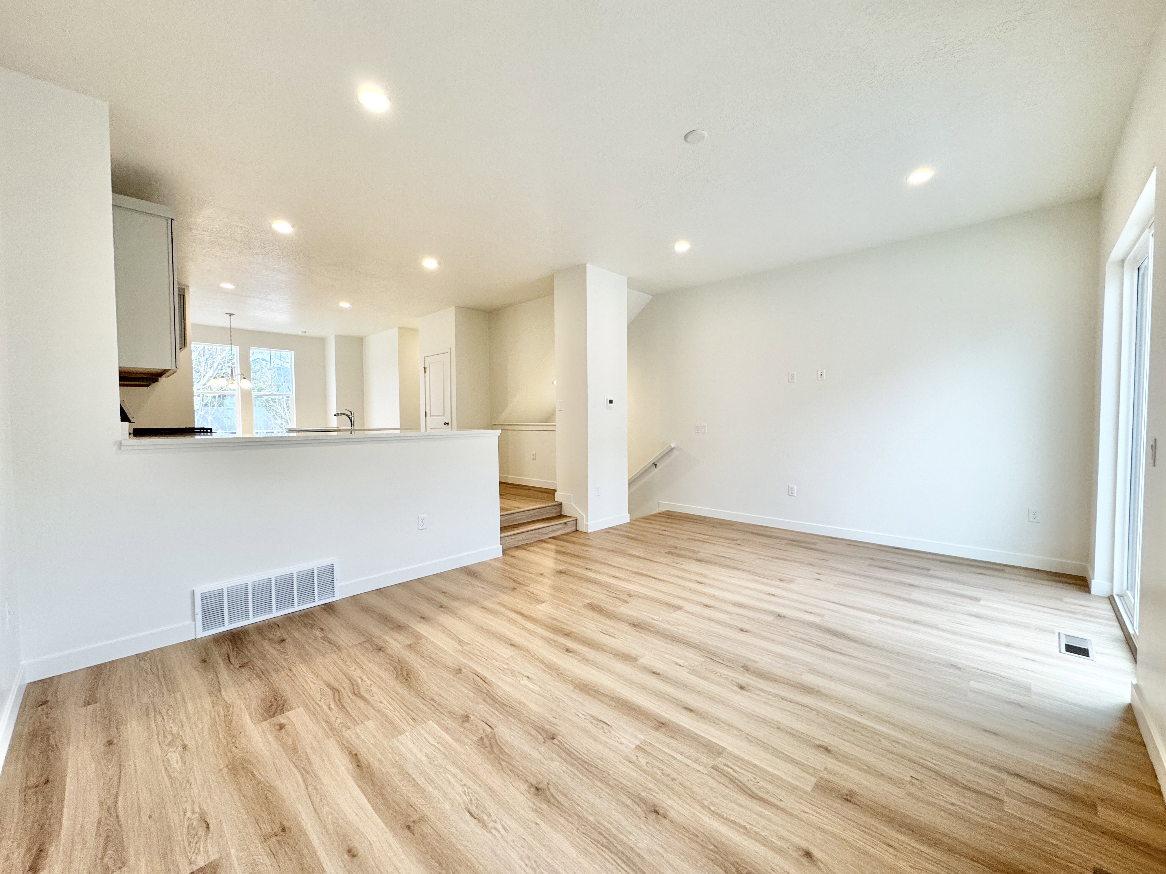 Open-concept main living area with wood-finish flooring