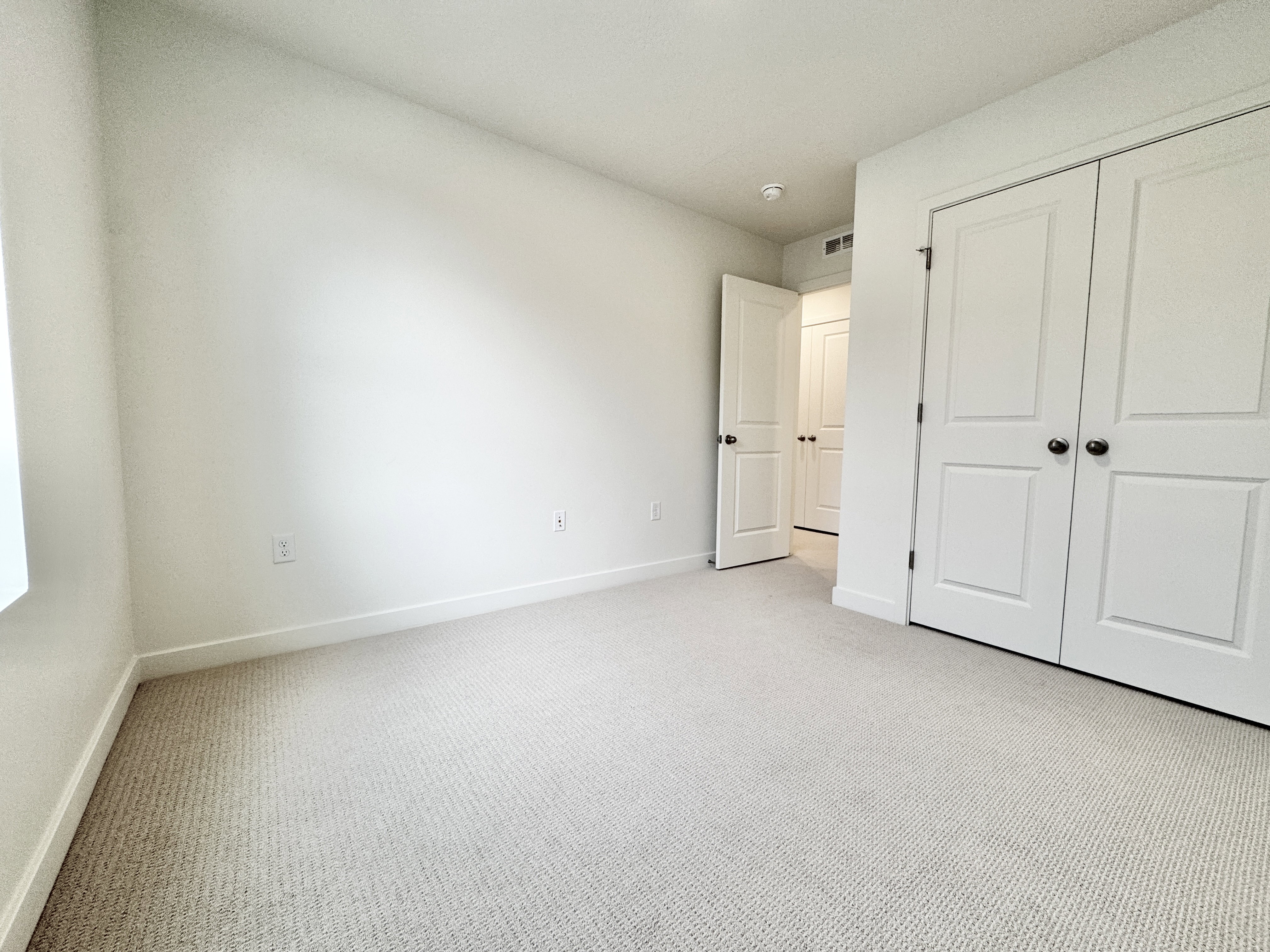 Neutral wall finishes with white trim and light-colored carpeting