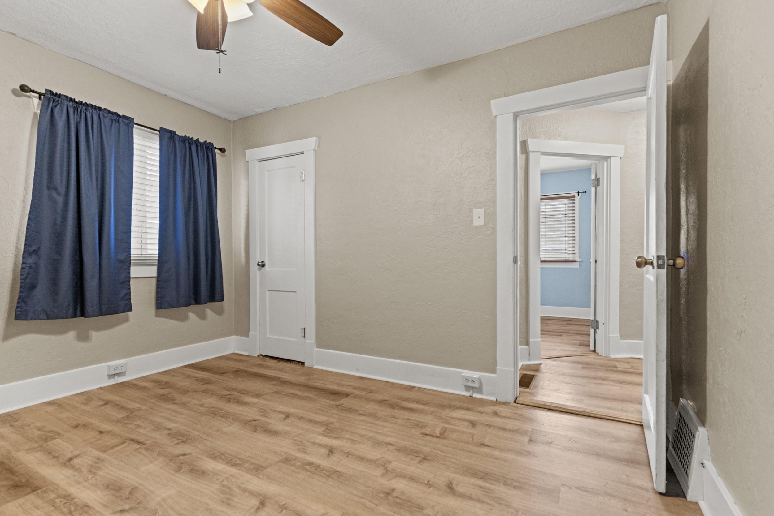 Interior room featuring wood-finish flooring, neutral wall tones, and white trim