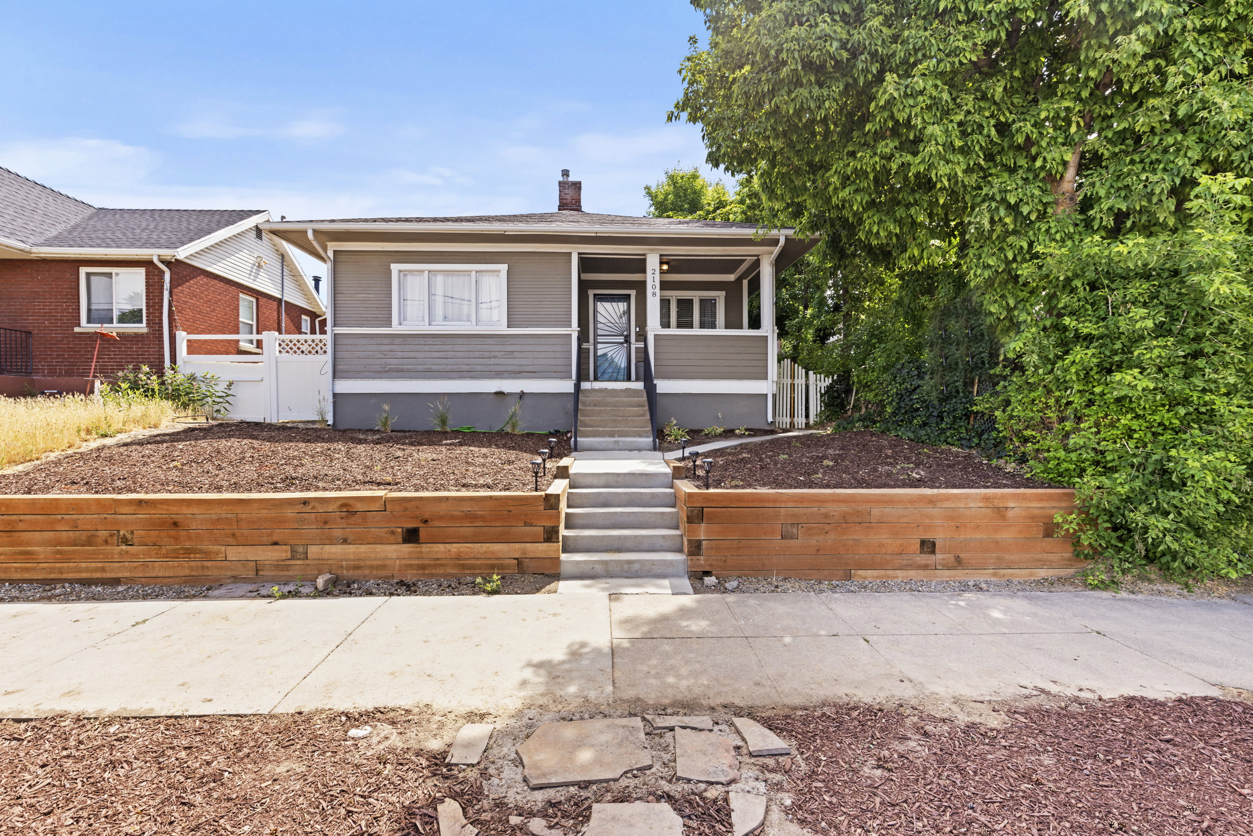 Single-story residence featuring a covered front porch, wood-look horizontal siding, and a contrasting foundation