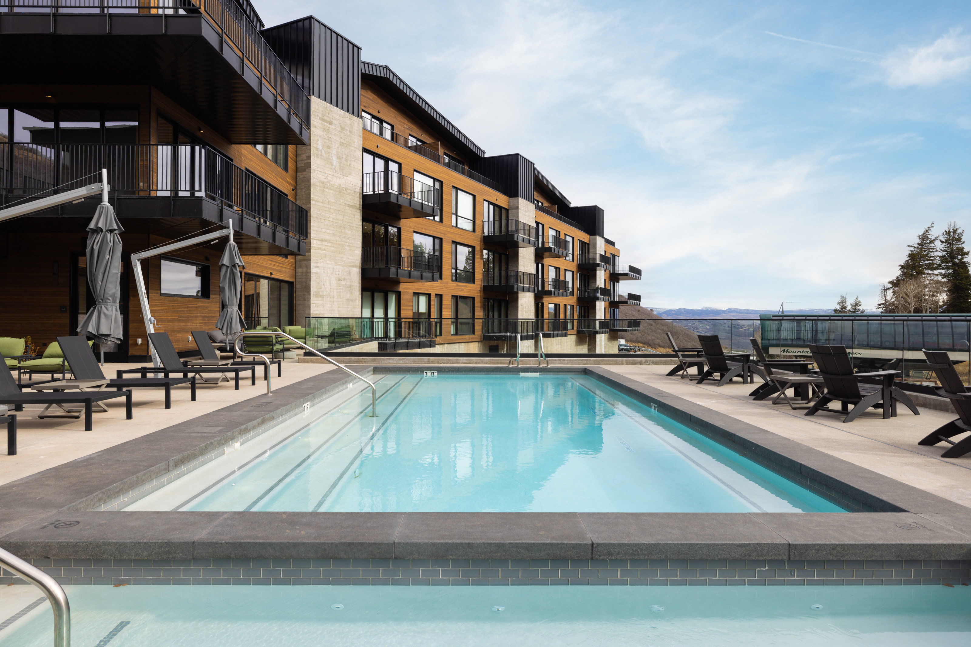 Outdoor swimming pool with integrated spa, flanked by a paver deck