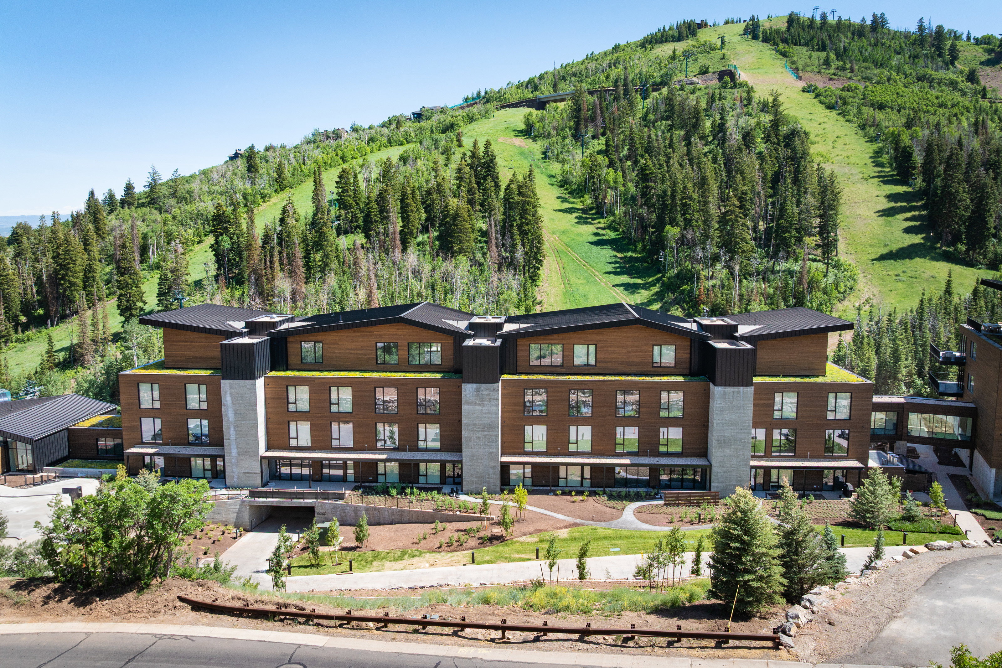 Multi-story building featuring wood-finish siding, concrete accents, and a distinctive roofline