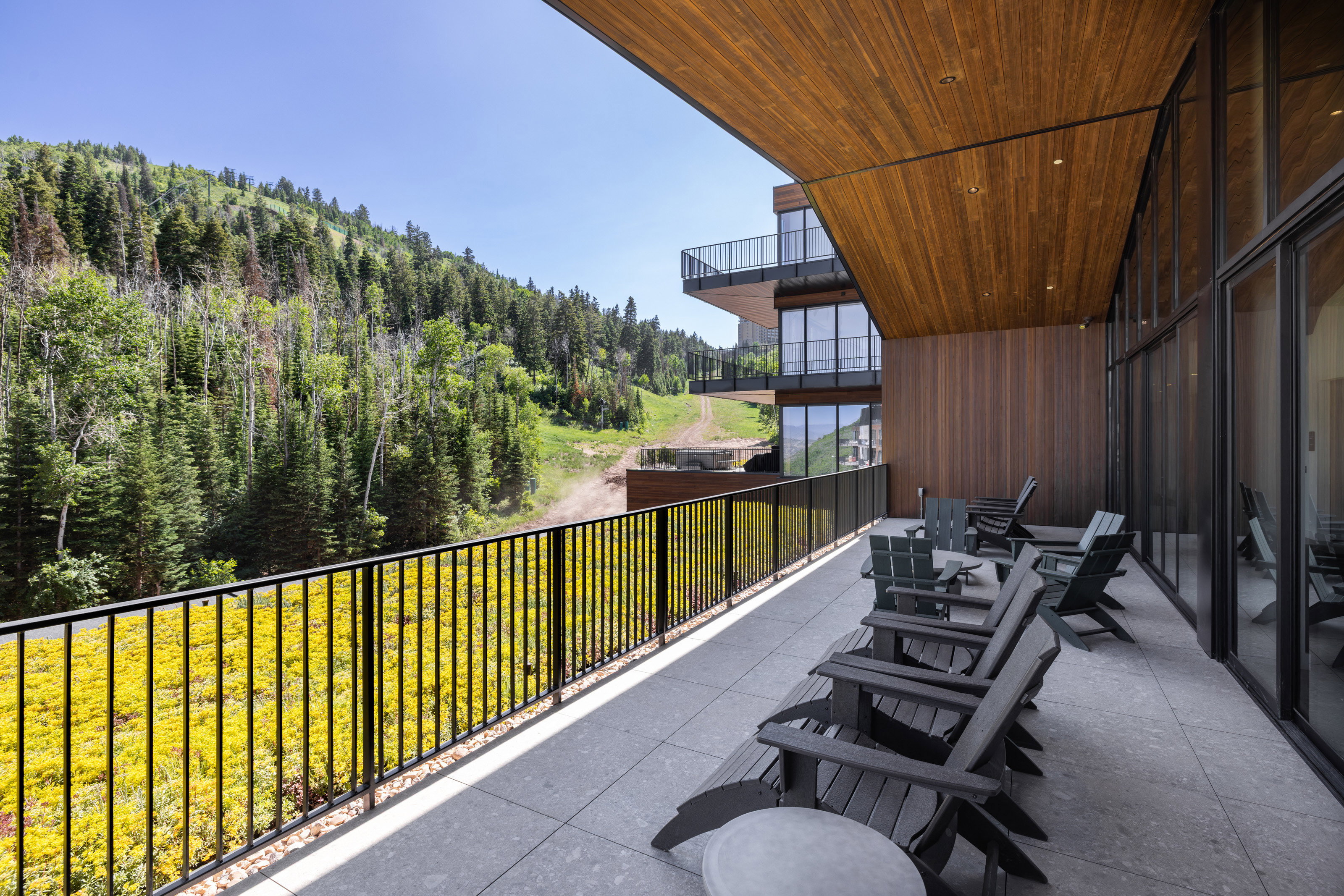 Expansive outdoor patio with a wood-finish ceiling and a black metal railing