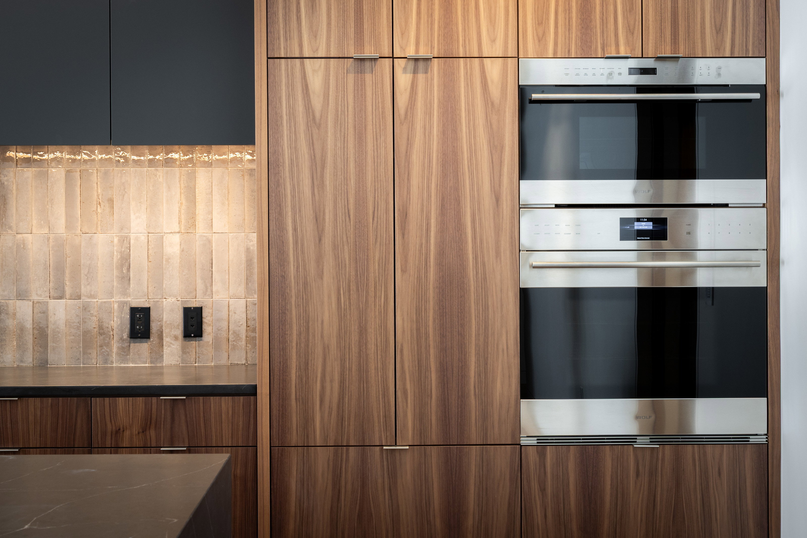 Integrated stainless steel double oven, surrounded by vertical grain wood cabinetry